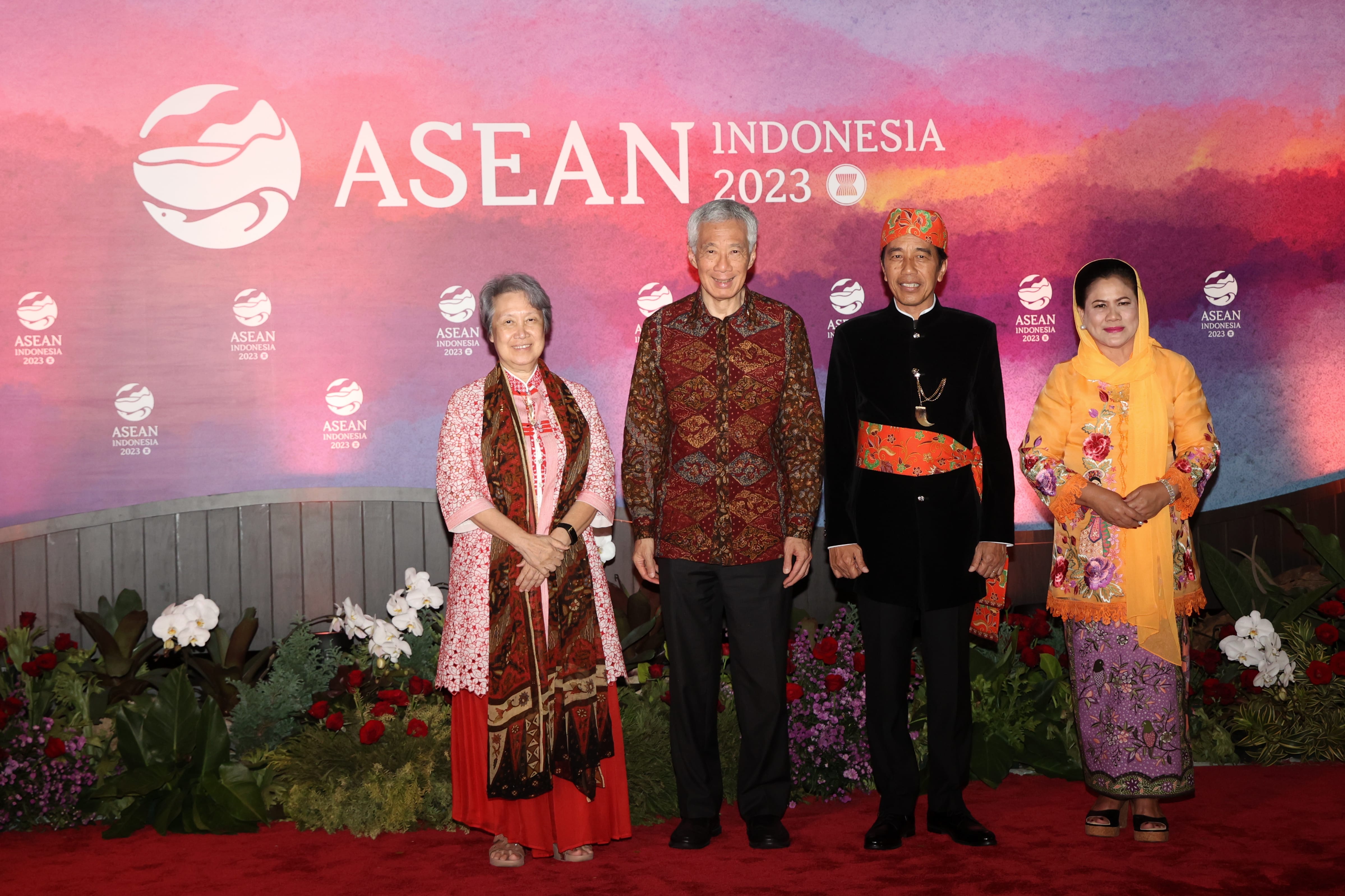 Four people standing in front of an ASEAN Indonesia 2023 logo backdrop.
