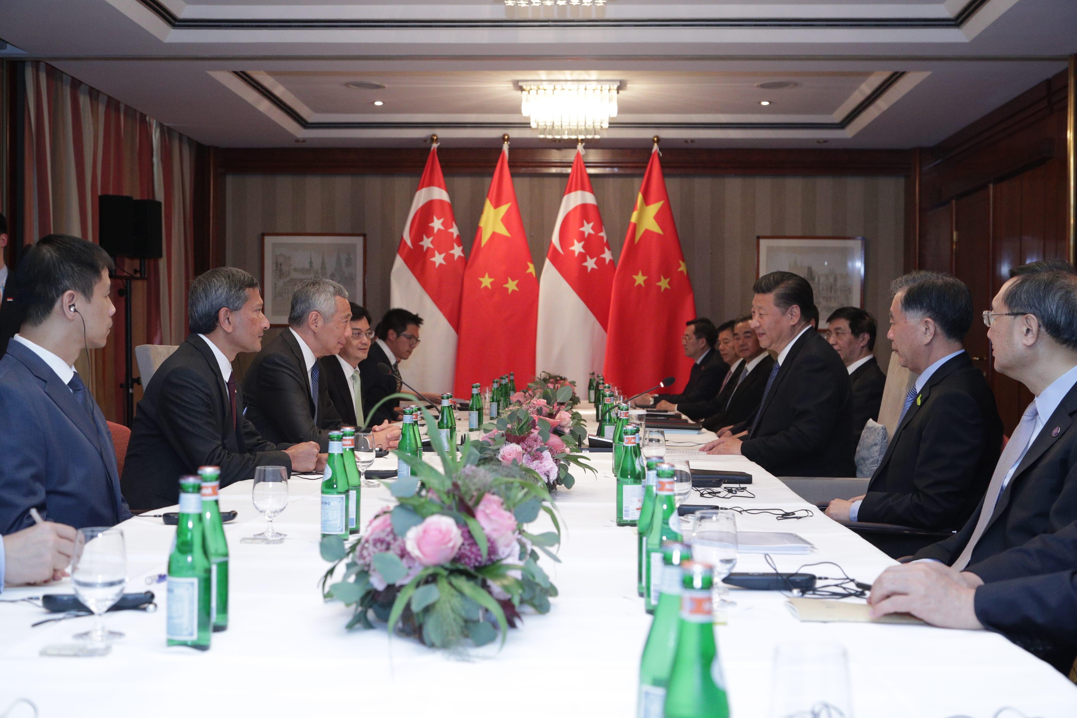 Xi Jinping & Lee Hsien Loong at table, San Pellegrino water, flags of China and Singapore.