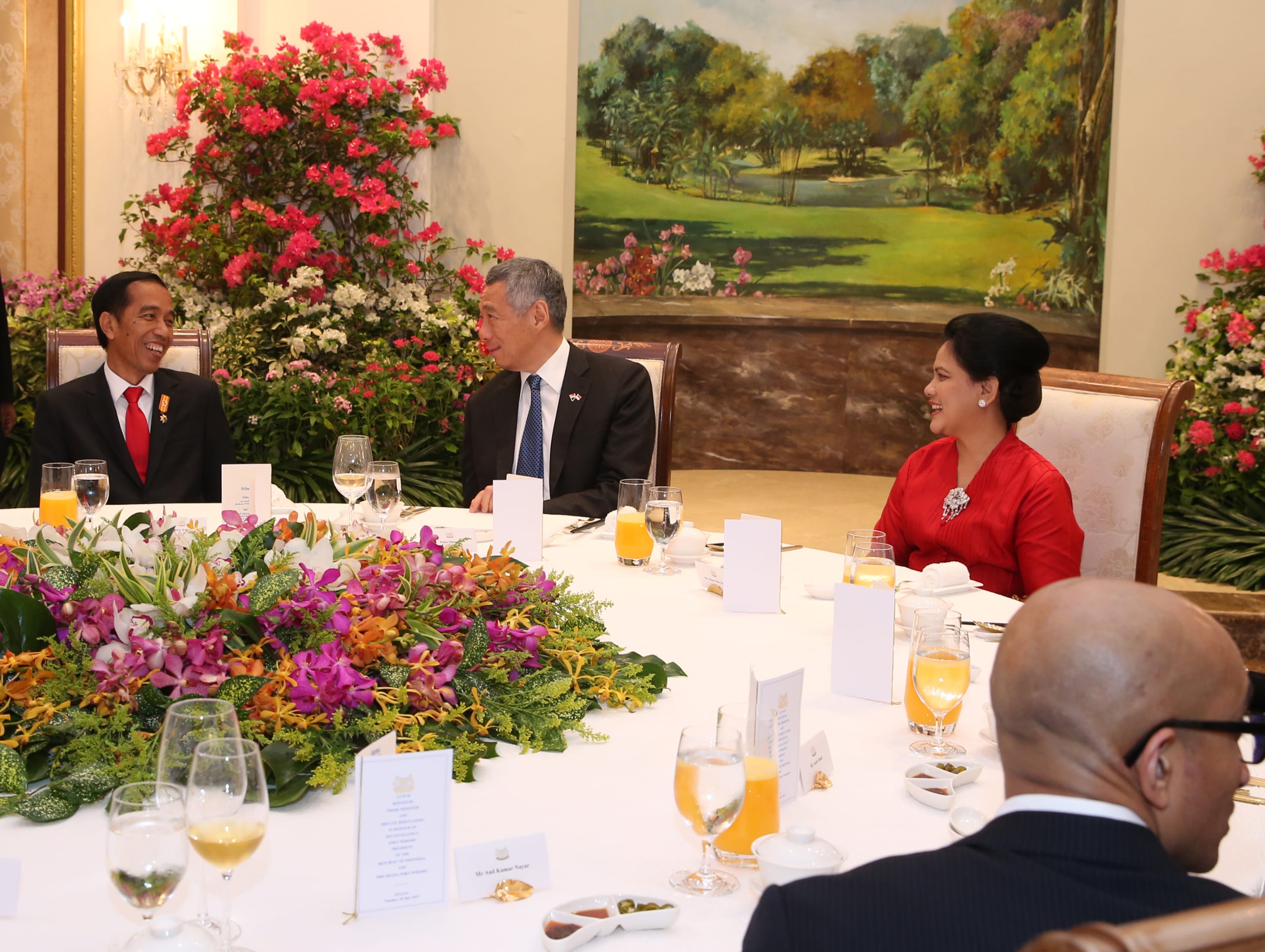 Lee Hsien Loong and Joko Widodo at a formal dinner, surrounded by floral arrangements.