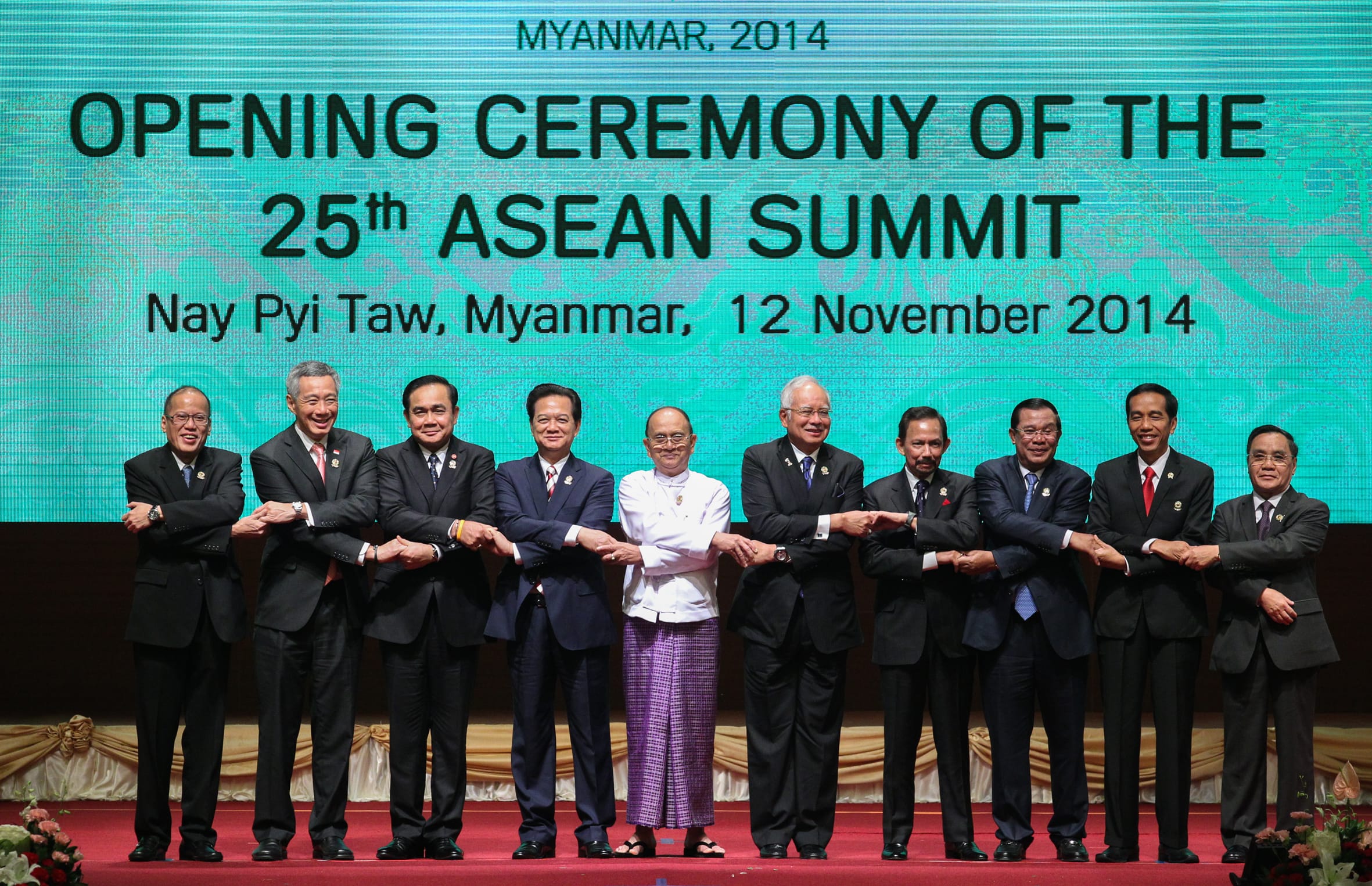 Group of leaders in suits holding hands at the 25th ASEAN Summit in Myanmar, 2014.