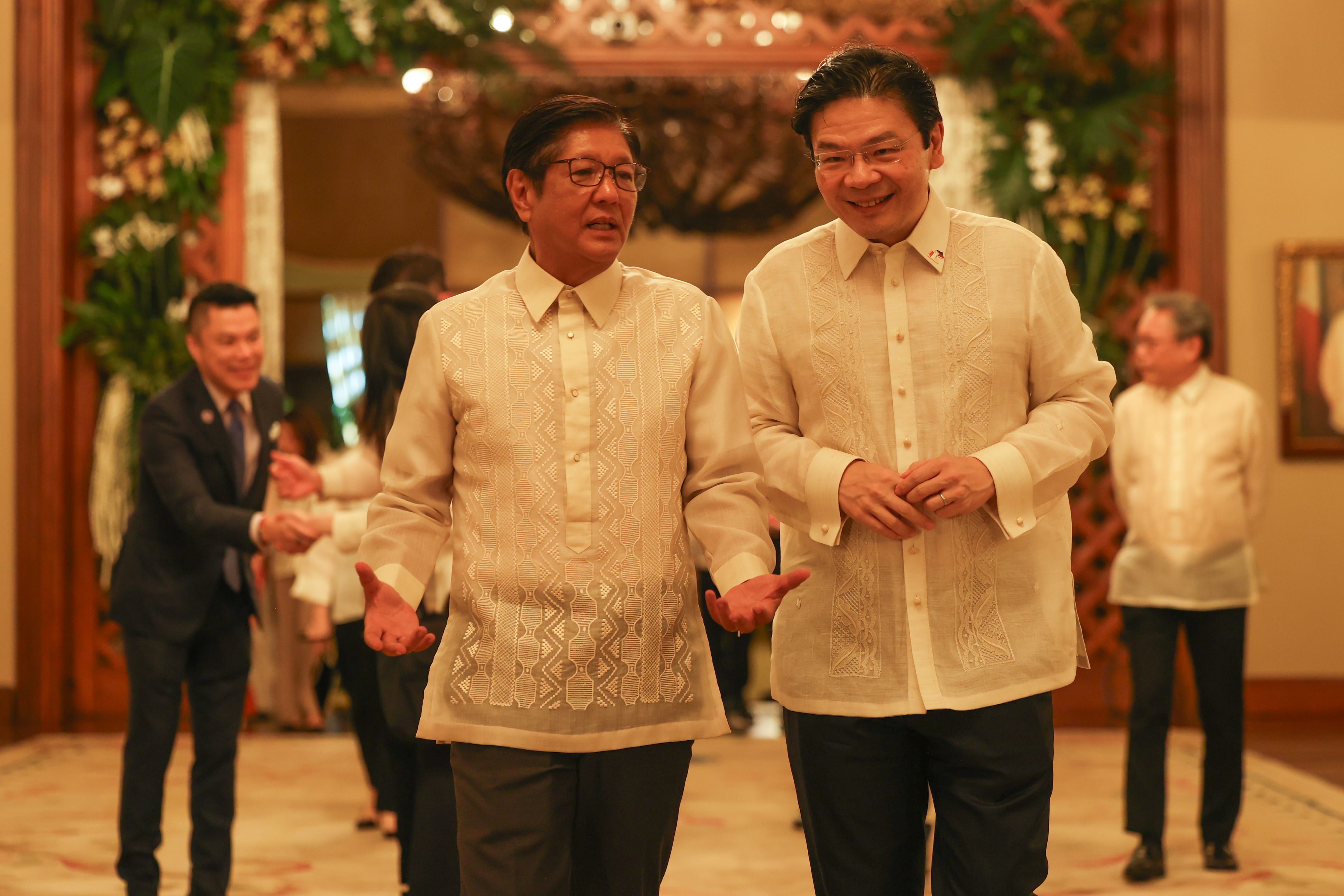 President Marcos Jr. with another man in a similar formal beige Barong Tagalog shirt.