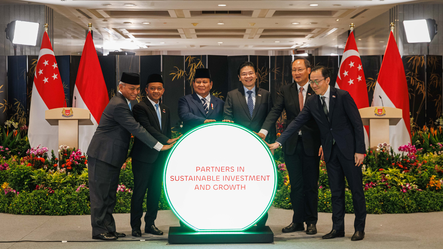Six people in suits hold a glowing circle with "Partners in Sustainable Investment and Growth" text. Flags in background.