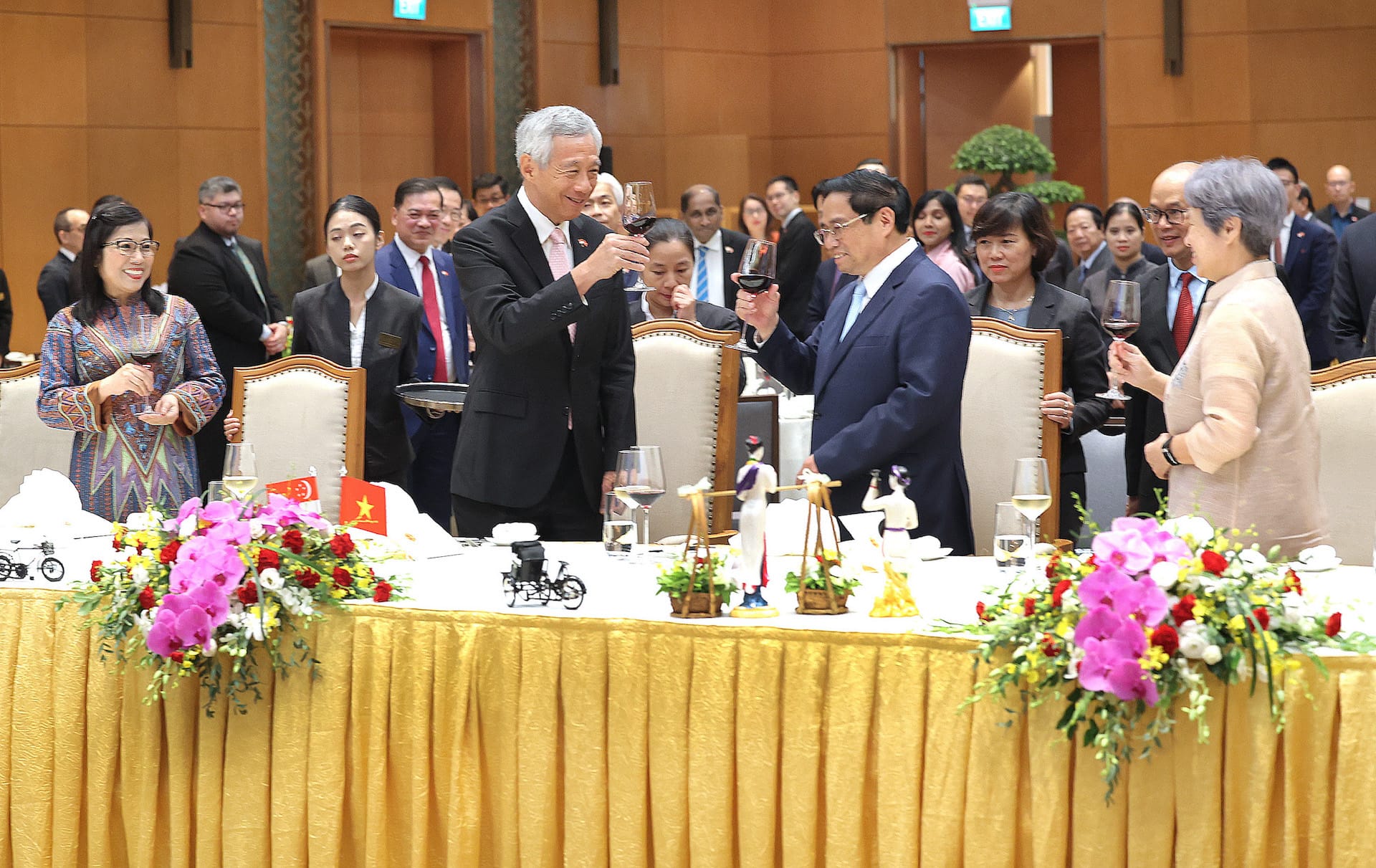 Heads of state Lee Hsien Loong and Phạm Minh Chính toast at a formal banquet with attendees.