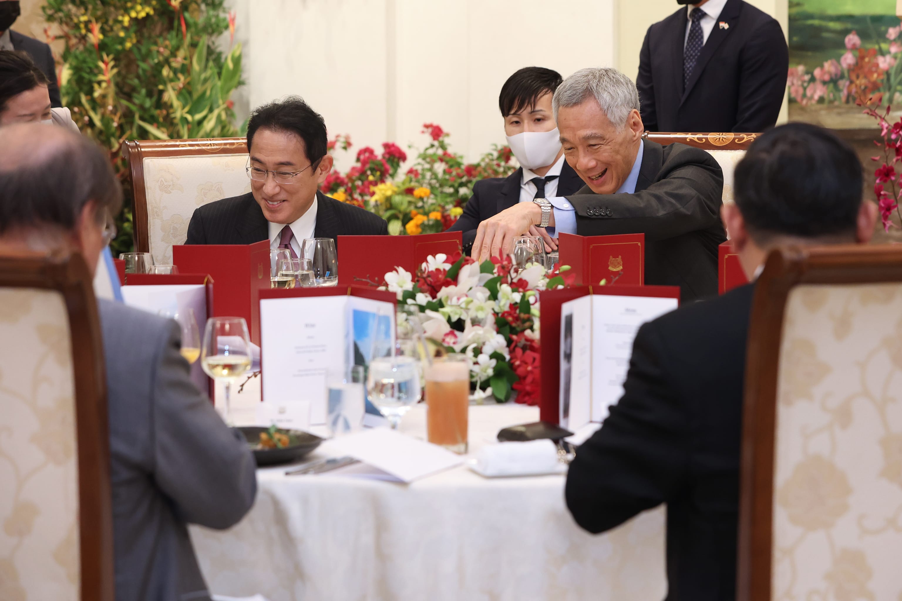 Kishida and Lee Hsien Loong at a formal dinner, smiling at a table.