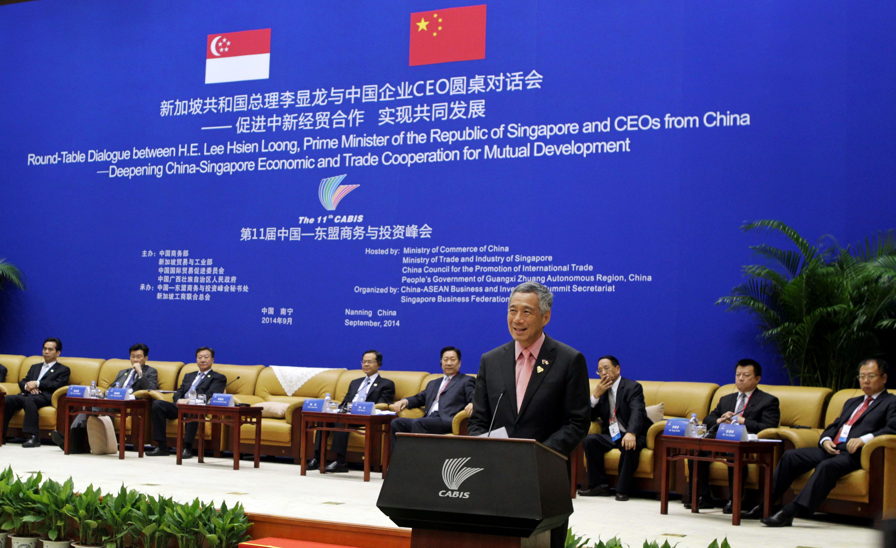 Lee Hsien Loong speaks at a CABIS roundtable with Chinese CEOs. Flags of China and Singapore displayed.