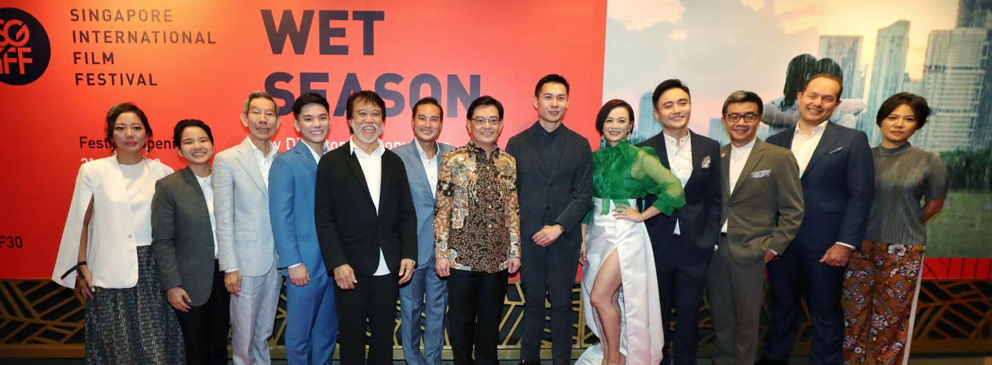 Group of people pose in front of a "Singapore International Film Festival" and "Wet Season" backdrop.