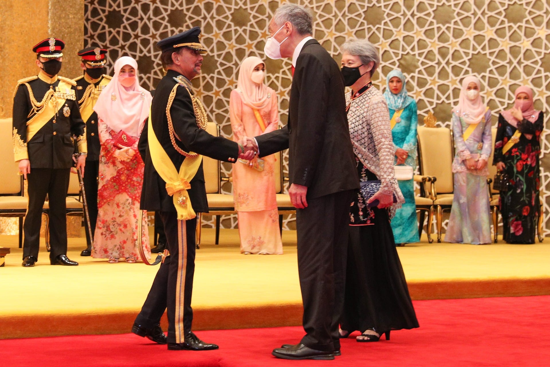 Sultan of Brunei and Singapore PM Lee Hsien Loong shaking hands in formal setting.