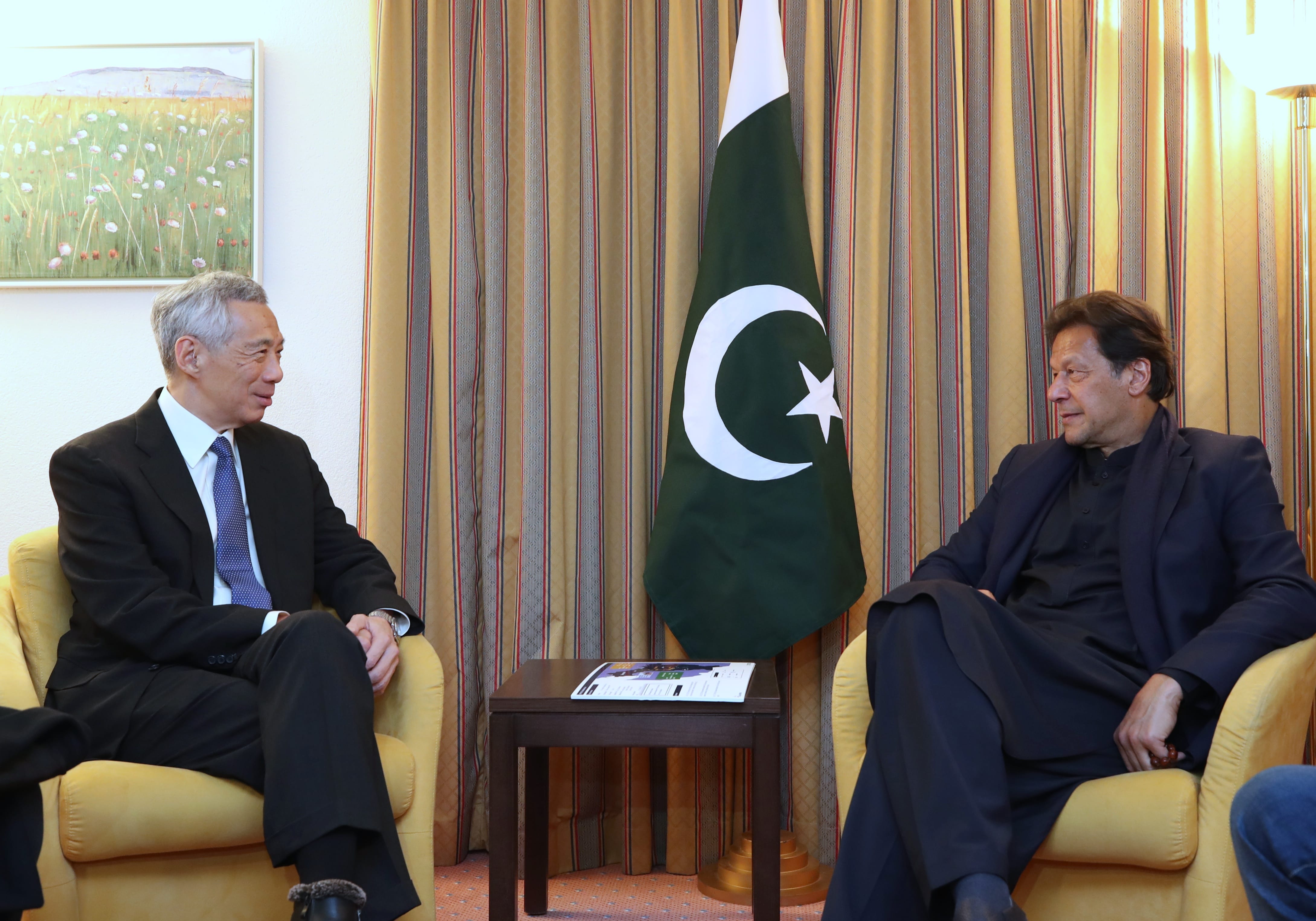 Lee Hsien Loong and Imran Khan sitting in chairs, with the Pakistan flag between them.