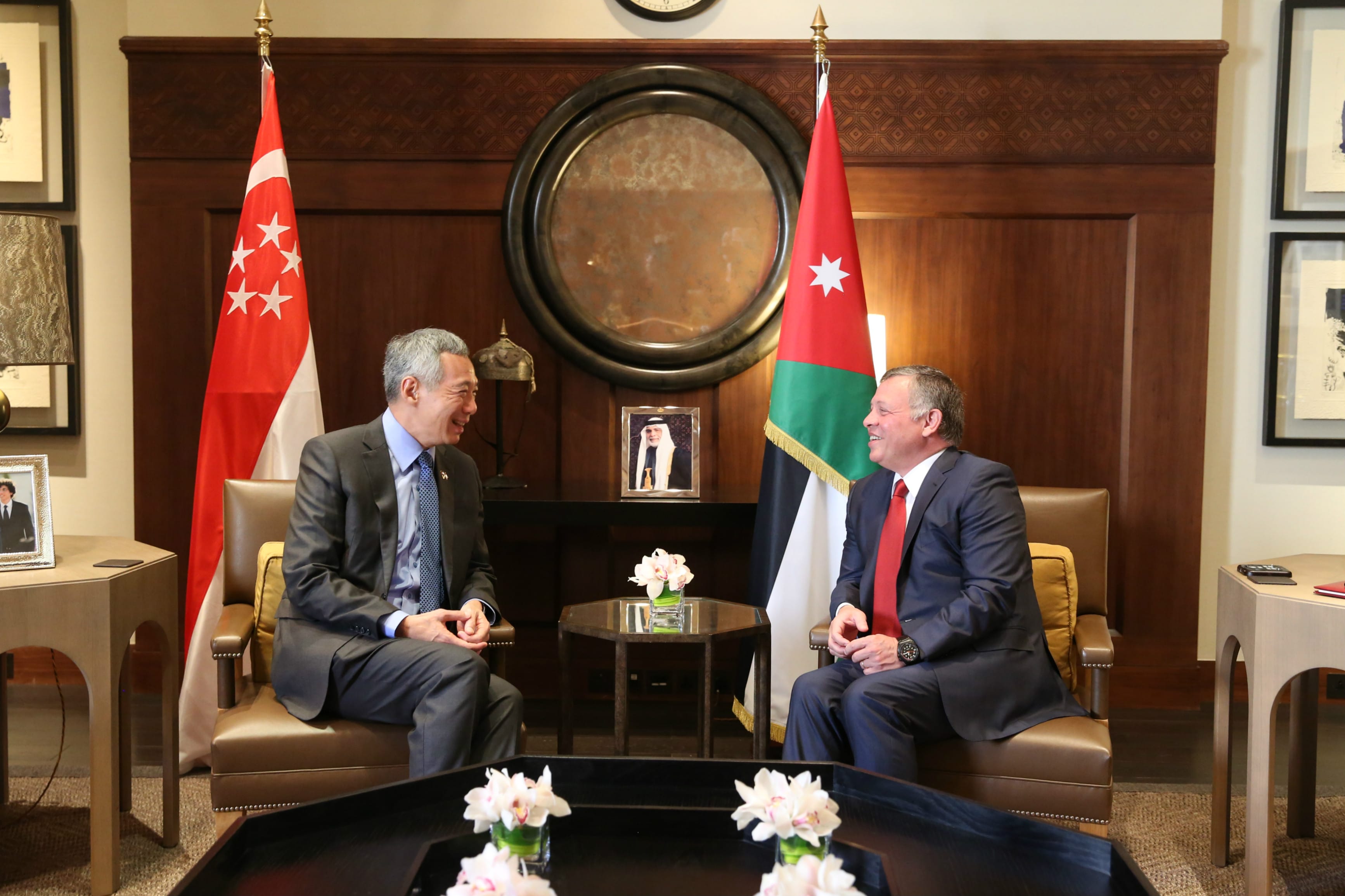 King Abdullah II and Lee Hsien Loong in suits, seated near flags of Jordan and Singapore.