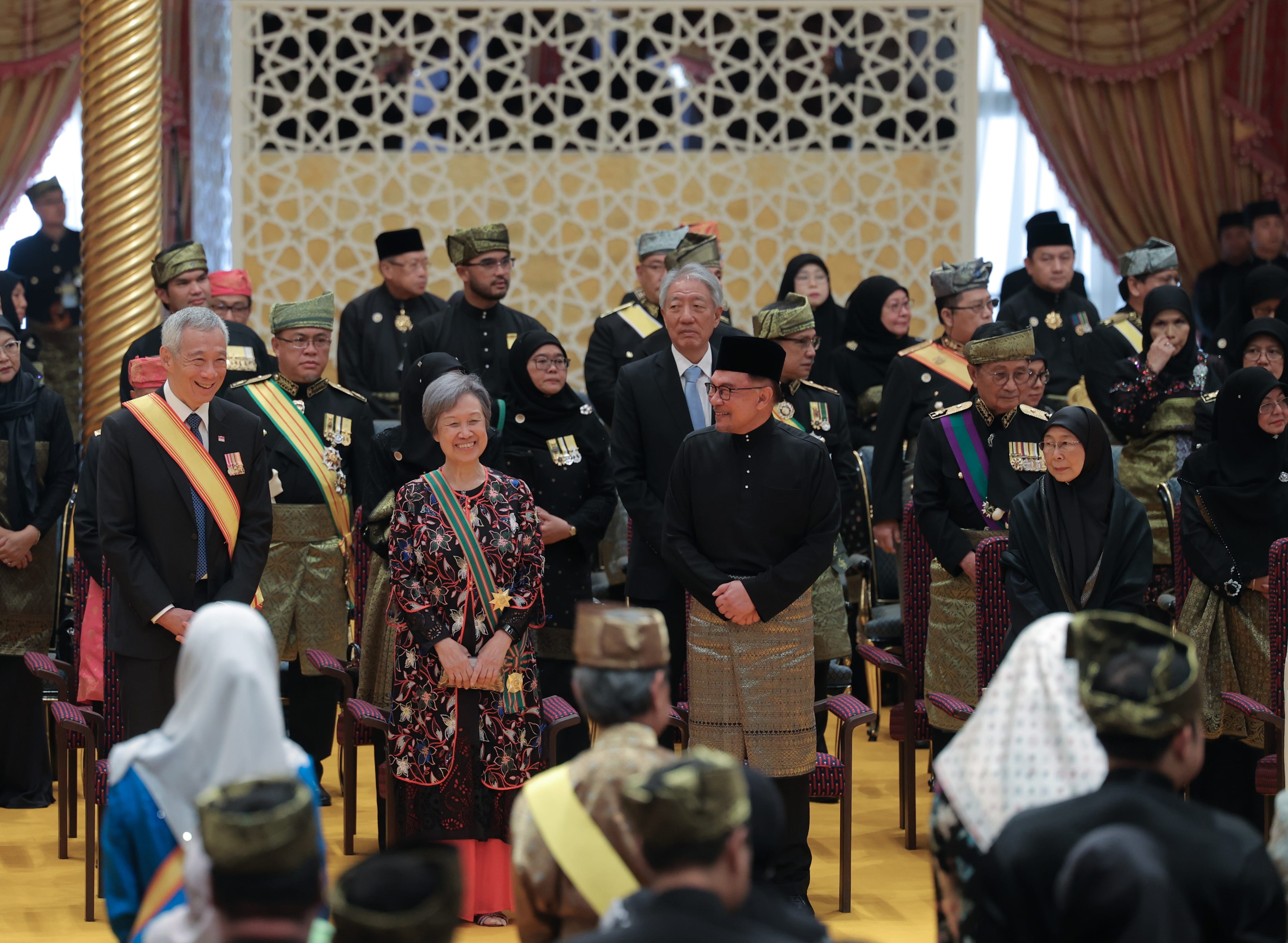 Lee Hsien Loong, Anwar Ibrahim, and dignitaries in formal attire, seated in ornate hall.