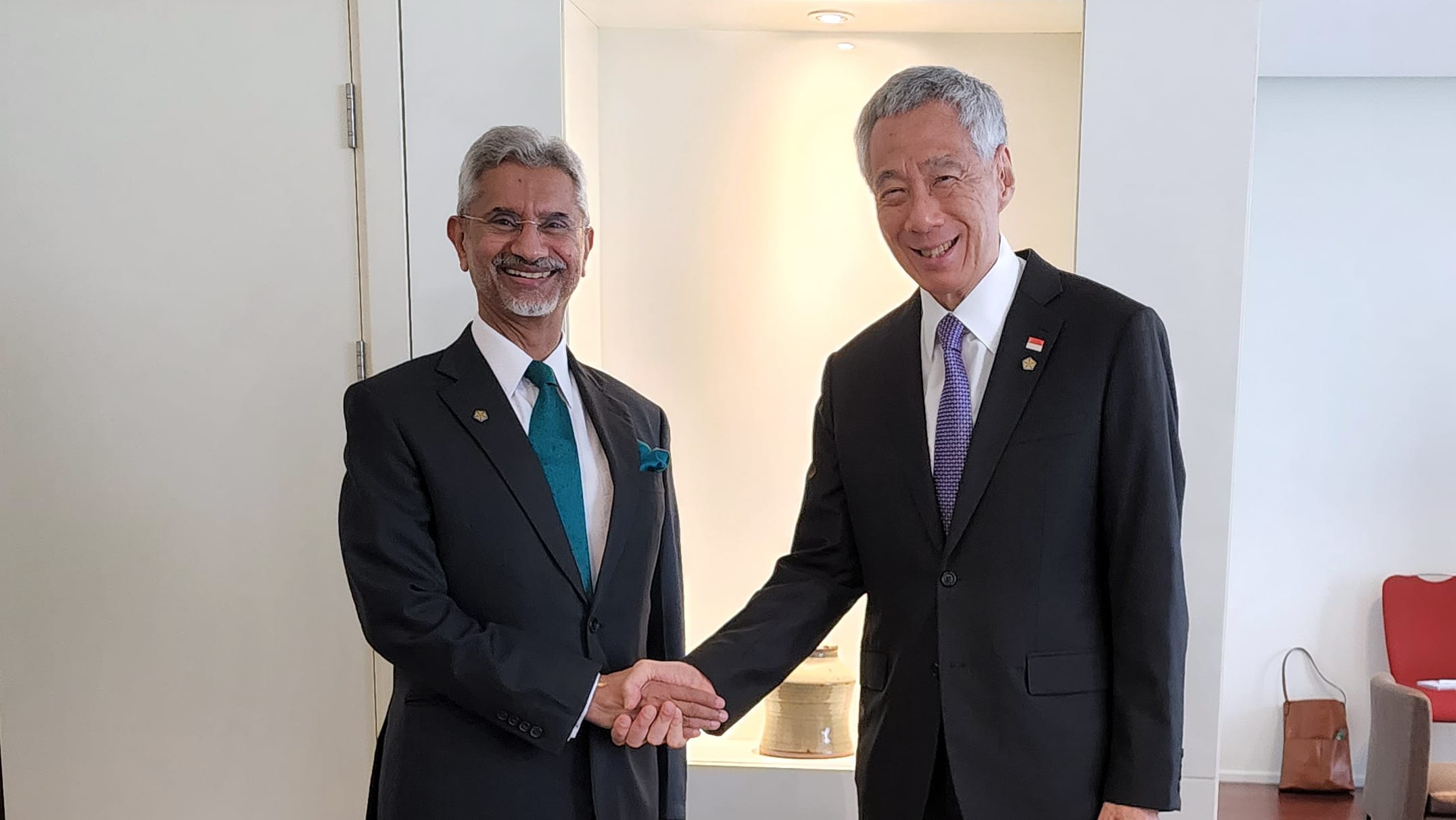 S. Jaishankar and Lee Hsien Loong in suits shake hands in a bright room.