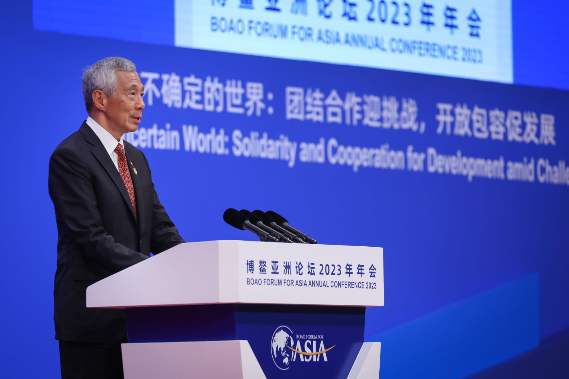 Lee Hsien Loong at a podium with microphones, backdrop for Boao Forum for Asia.