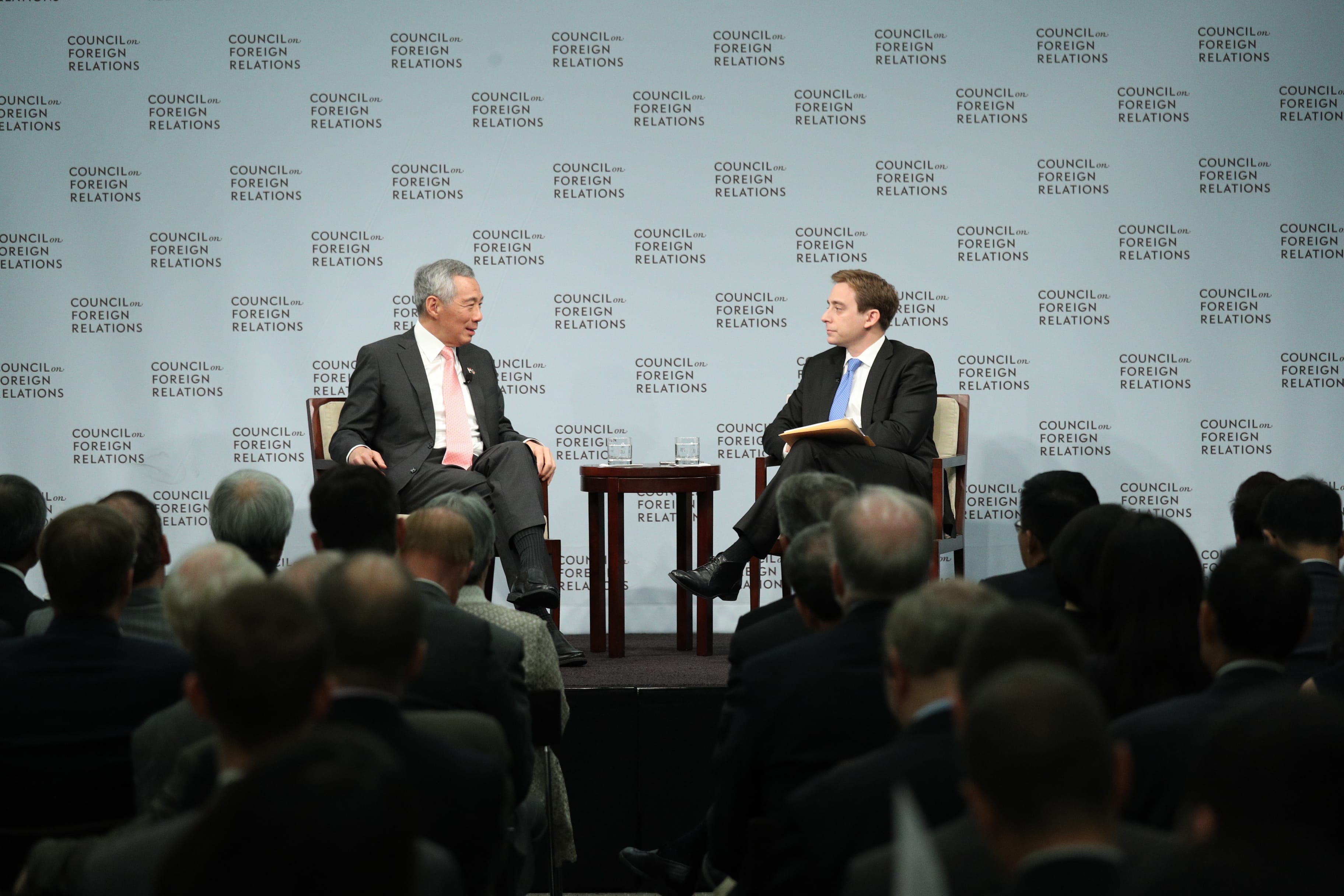 Two men on stage at a Council on Foreign Relations event, speaking to an audience.