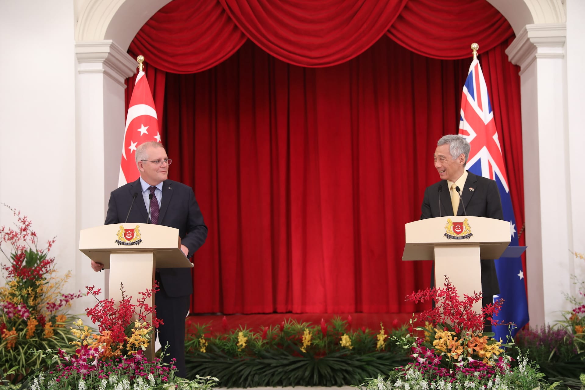 Scott Morrison & Lee Hsien Loong at lecterns with Singapore and Australia flags, red drapes.