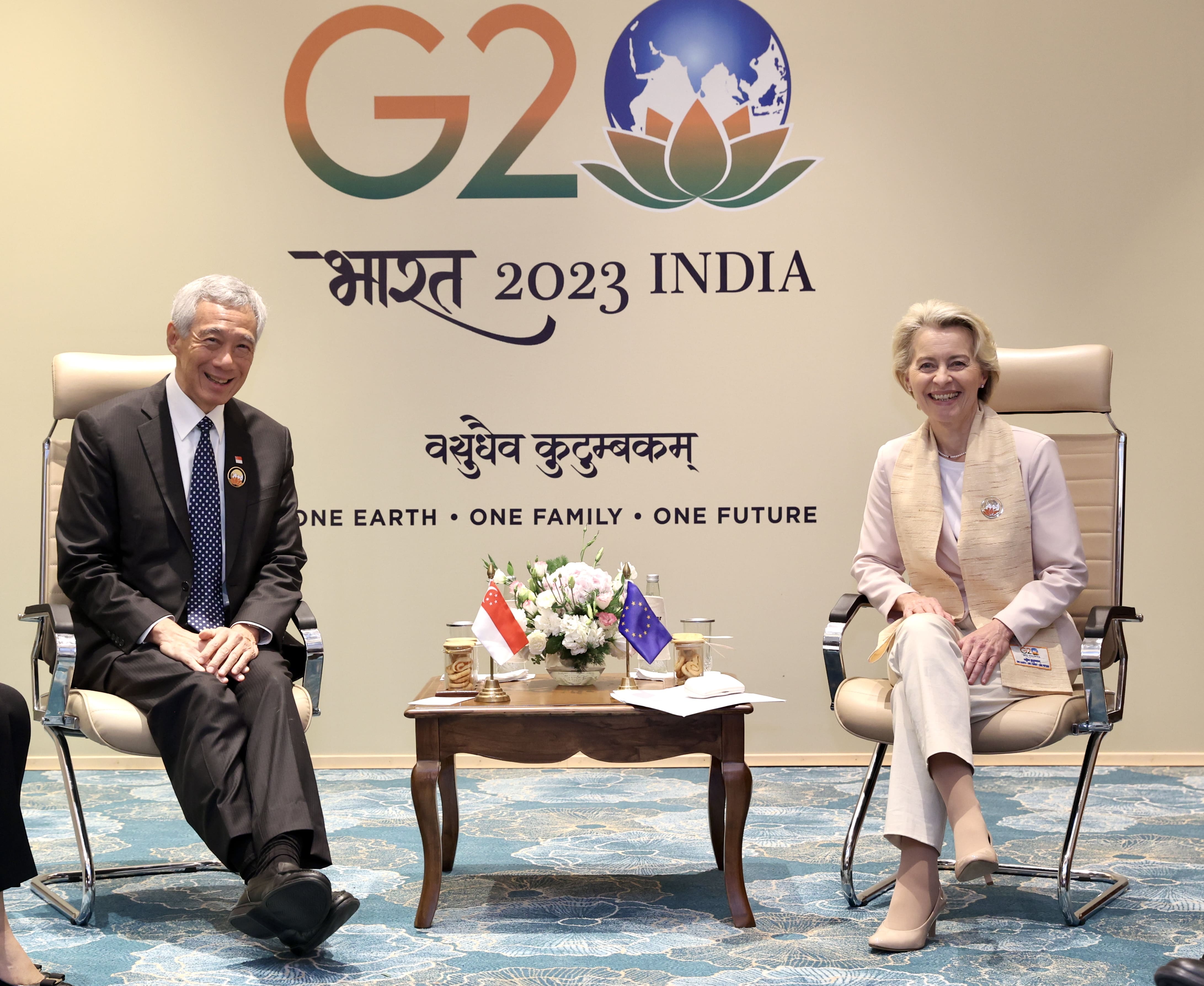 Lee Hsien Loong and Ursula von der Leyen sit before a G20 backdrop. Flags of Singapore and EU are on the table.