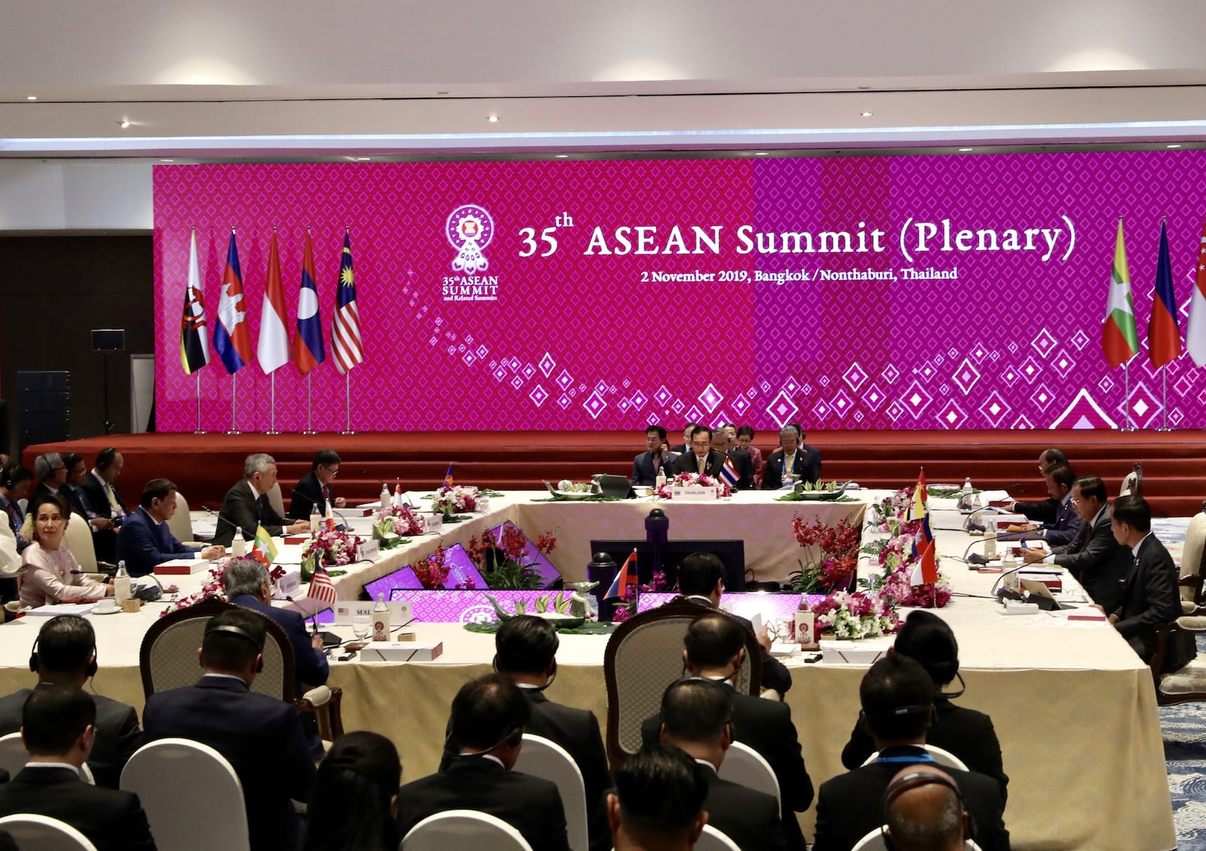 35th ASEAN Summit plenary in Bangkok, 2019, with attendees seated at tables, flags, and a large pink backdrop.