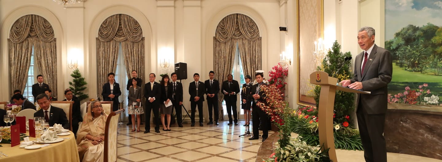 Lee Hsien Loong speaks at a podium before an audience in a large hall.