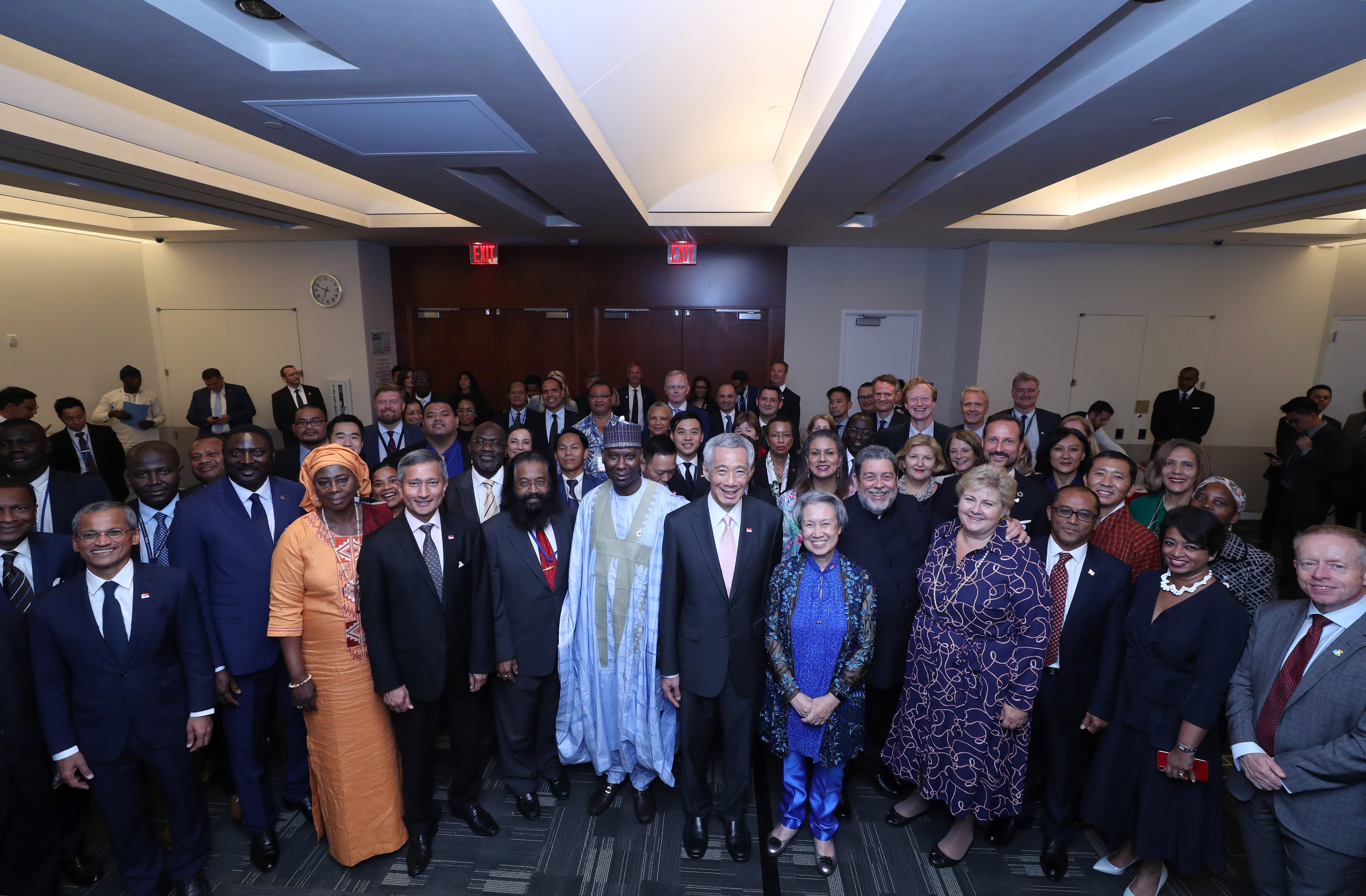 Group of people in formal wear posing indoors for a photo.