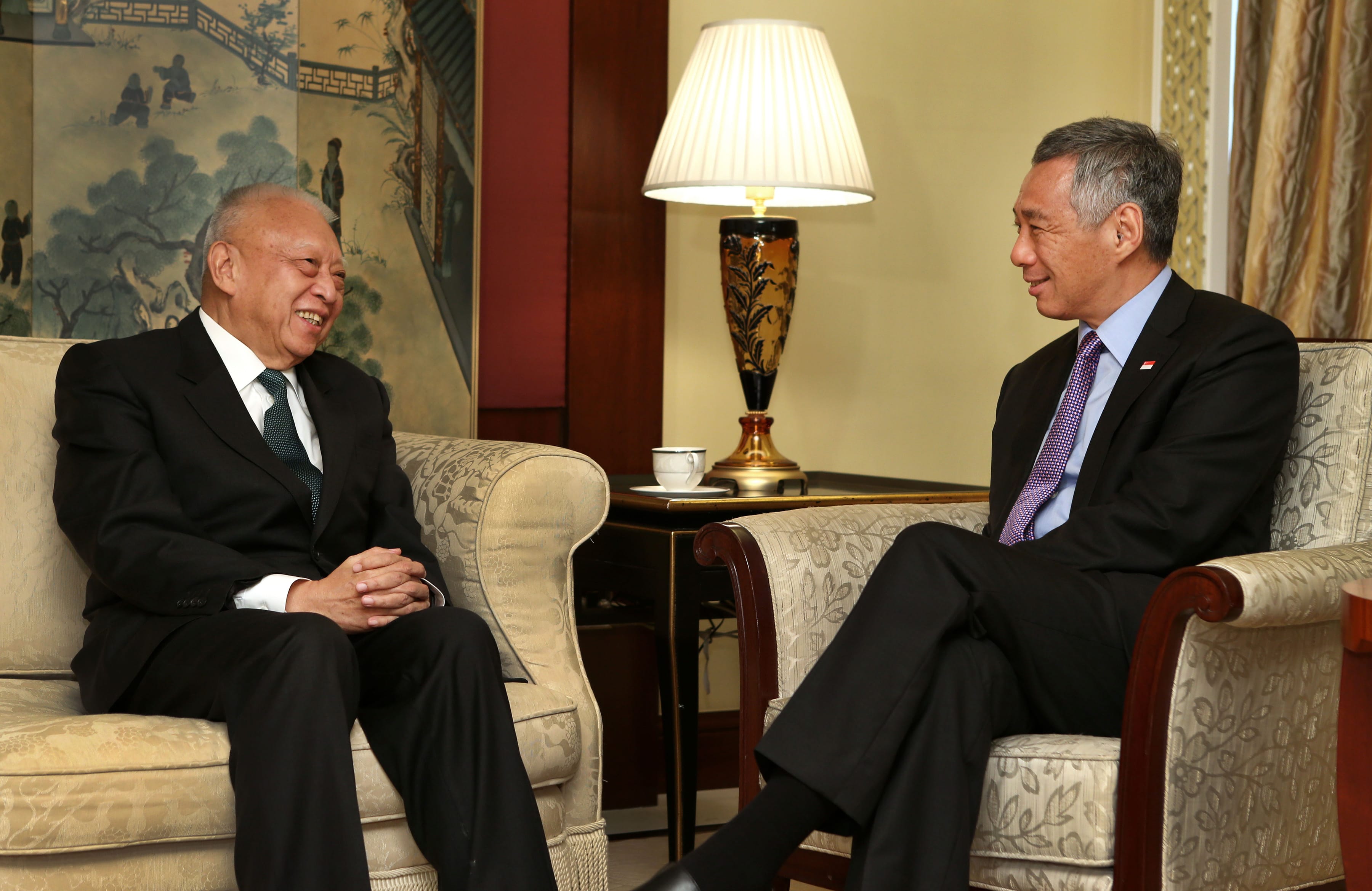 Two men in suits sit in ornate chairs facing each other, Lee Hsien Loong on the right.