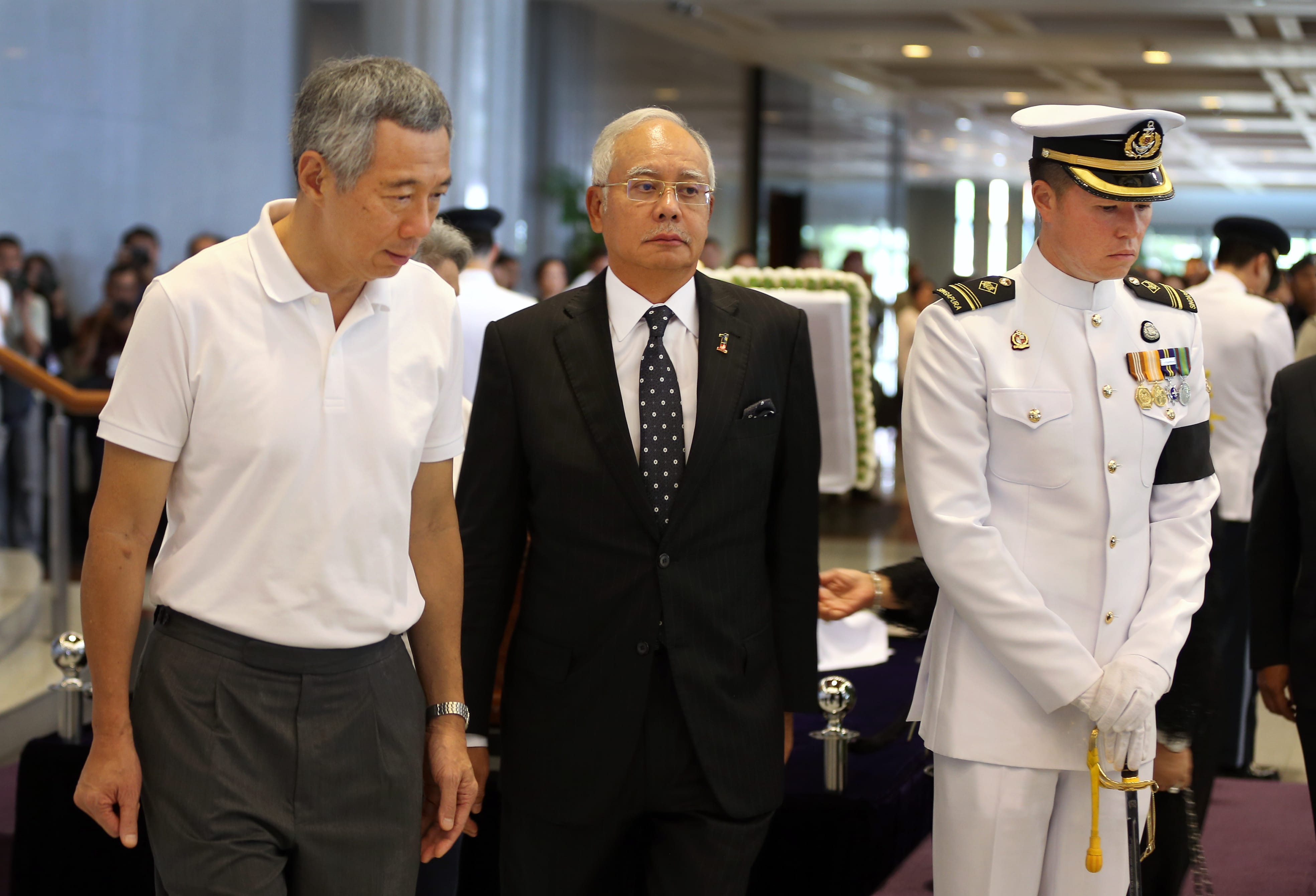 Lee Hsien Loong, Najib Razak and a Singaporean soldier in uniform stand together.