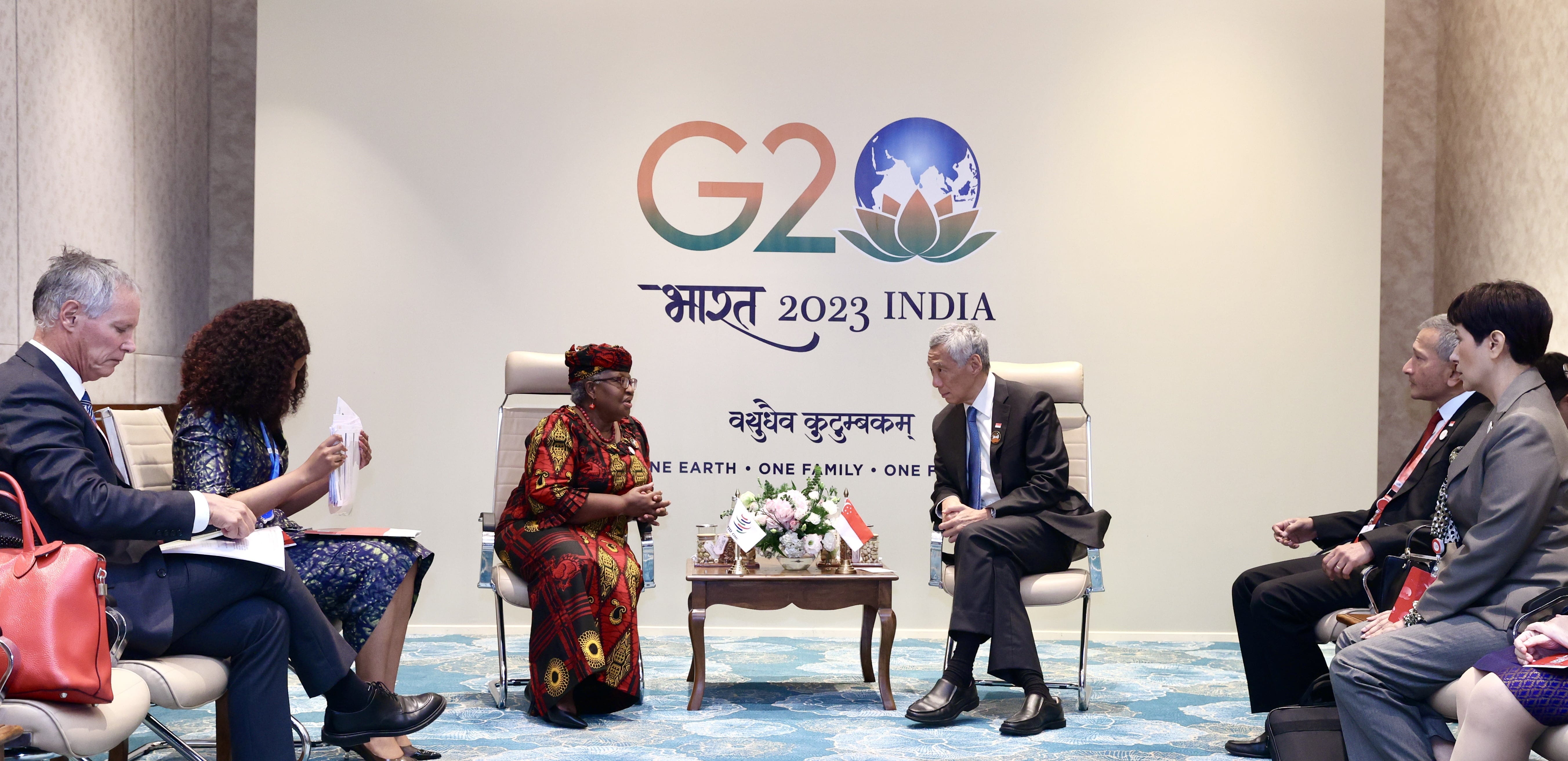 Ngozi Okonjo-Iweala and Lee Hsien Loong converse at G20 India 2023, audience members sit nearby.