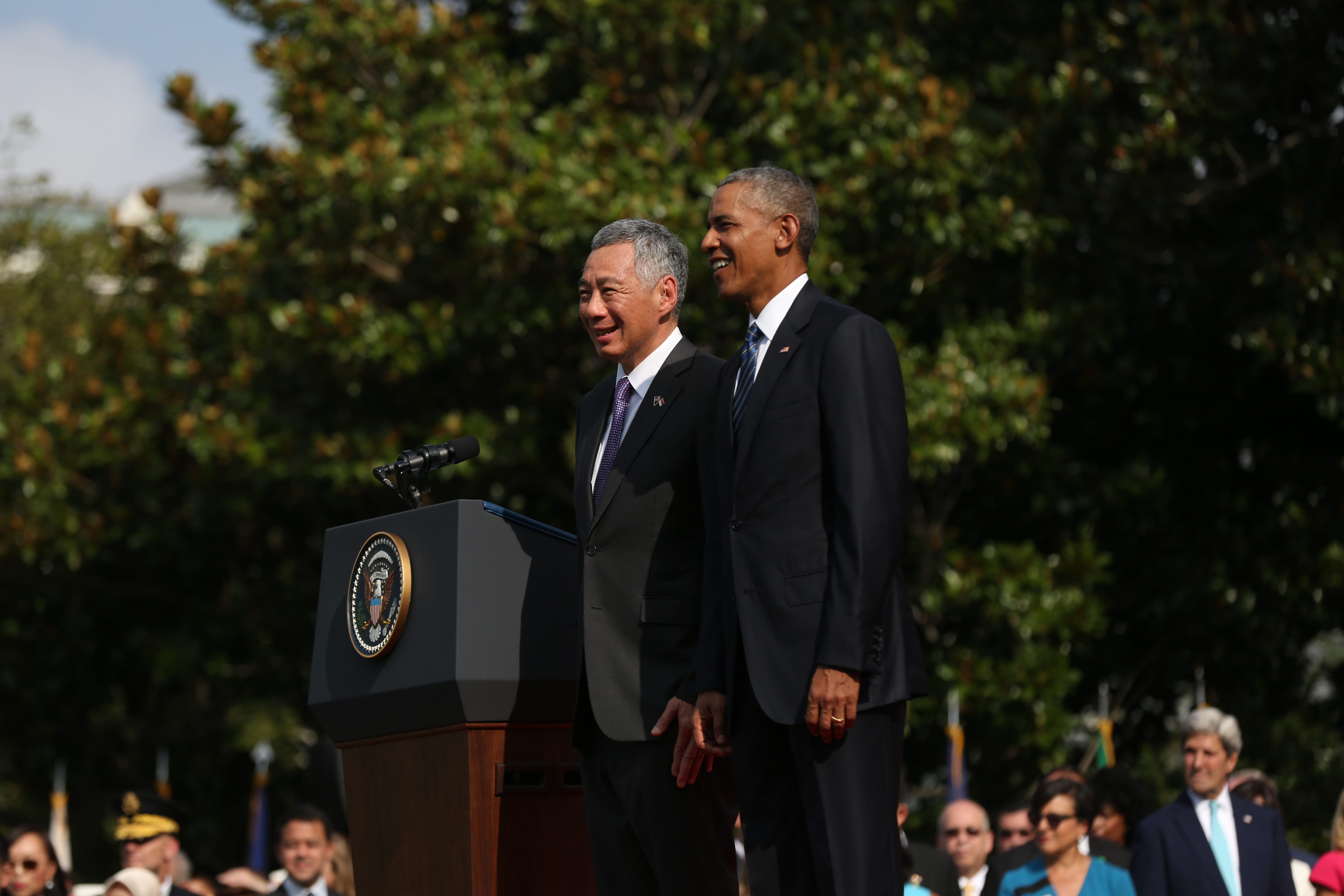 Barack Obama and Lee Hsien Loong in suits stand near a podium with US seal.