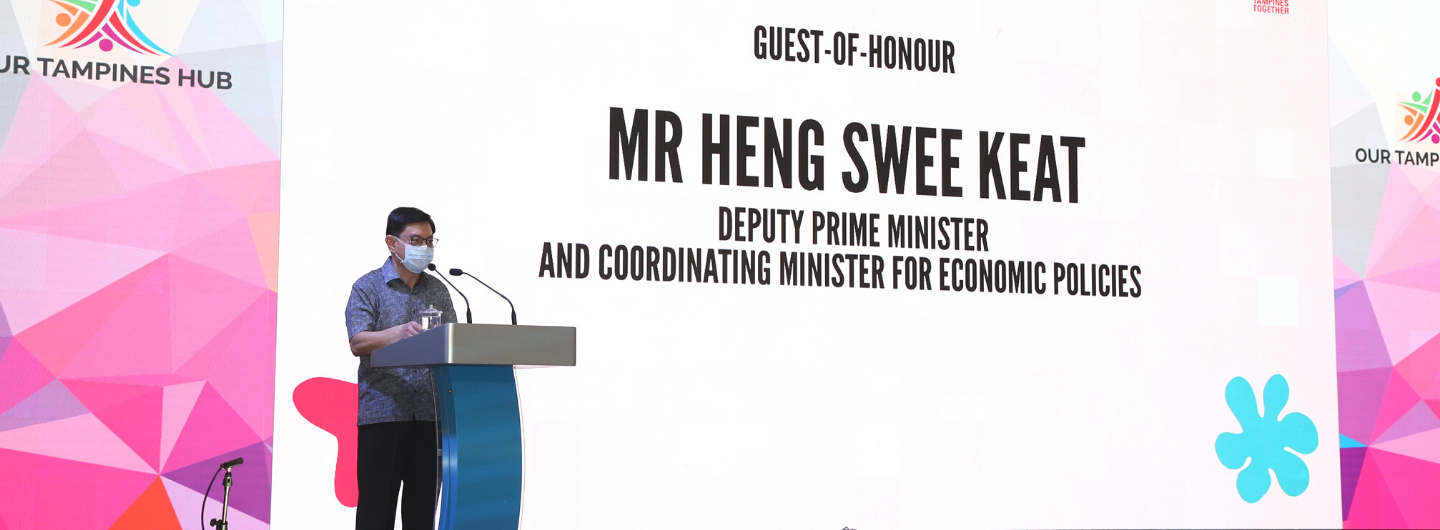 Mr. Heng Swee Keat, masked, at a podium with "Our Tampines Hub" backdrop.