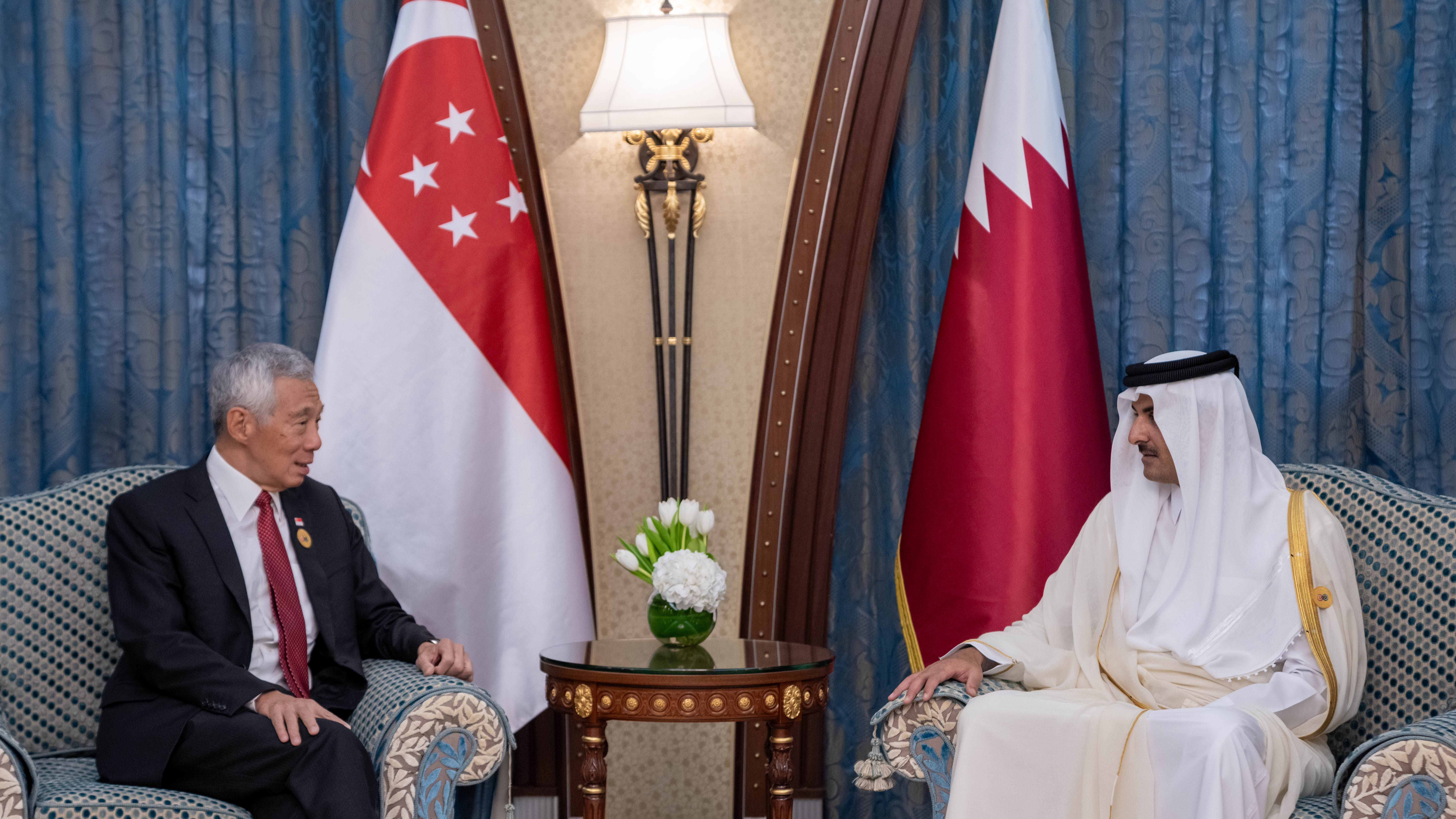 Singapore's Lee Hsien Loong and Qatar's Sheikh Tamim bin Hamad Al Thani meet, flags visible.