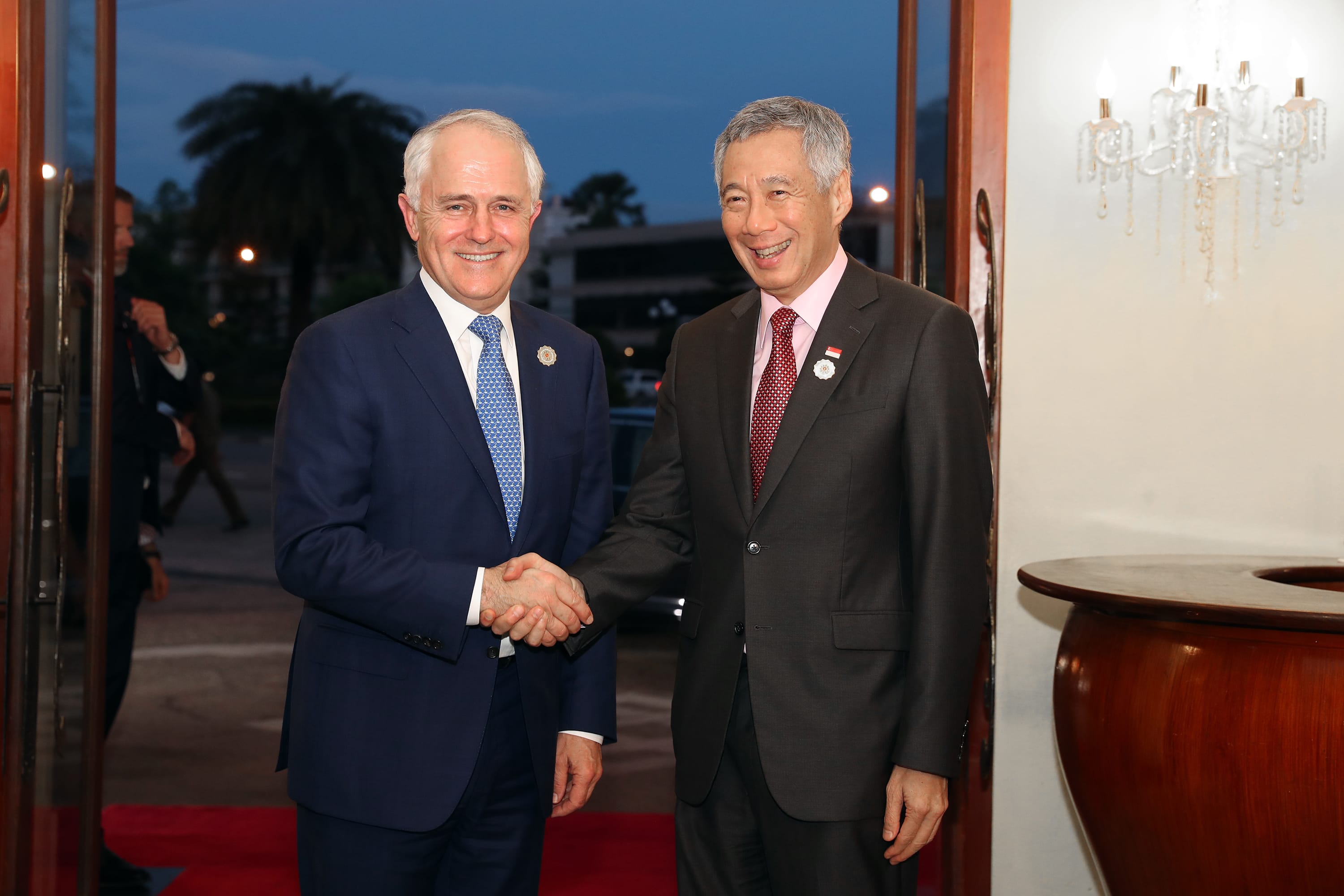 Malcolm Turnbull and Lee Hsien Loong in suits shake hands.