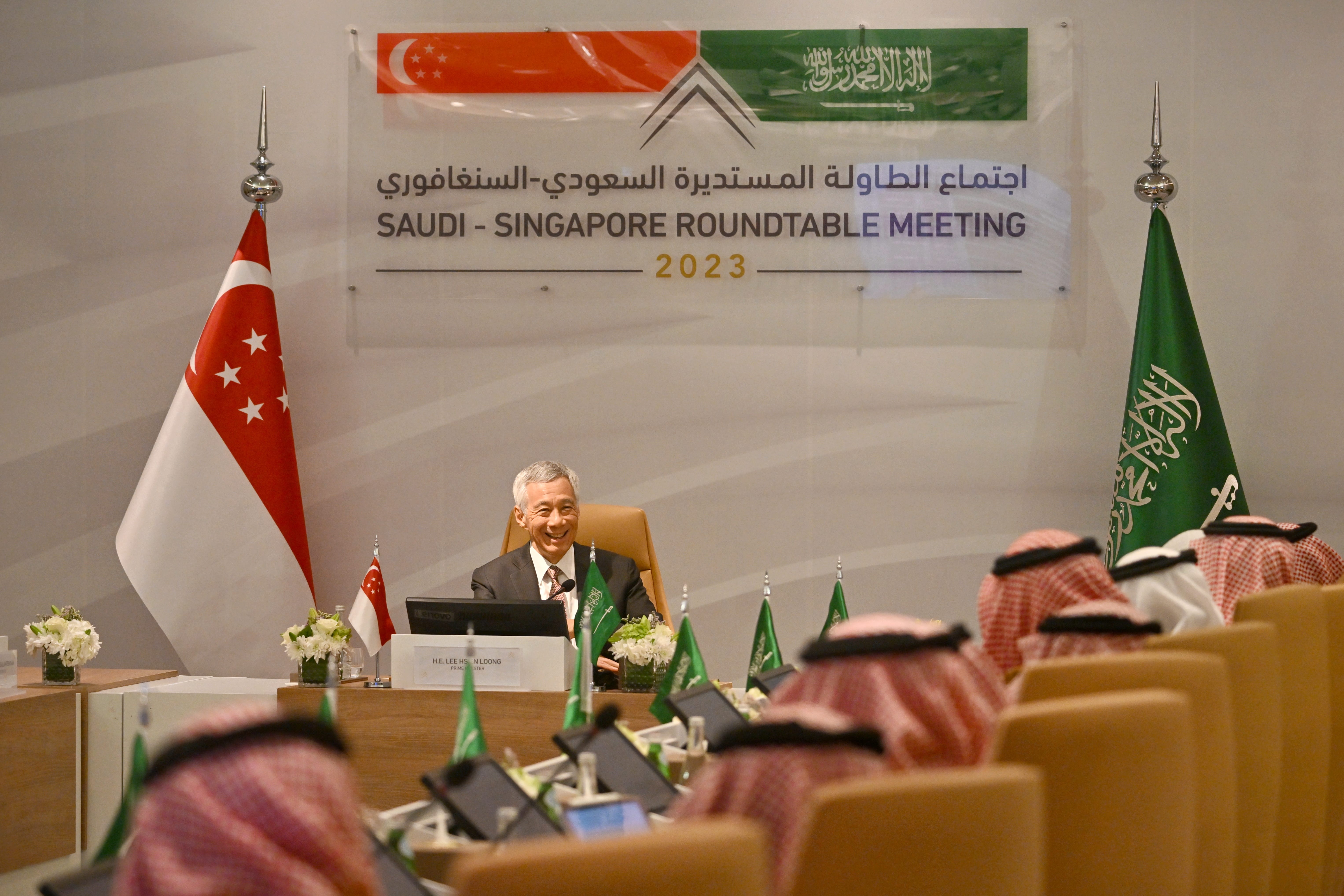 Lee Hsien Loong at Saudi-Singapore Roundtable Meeting with flags and Saudi delegates.