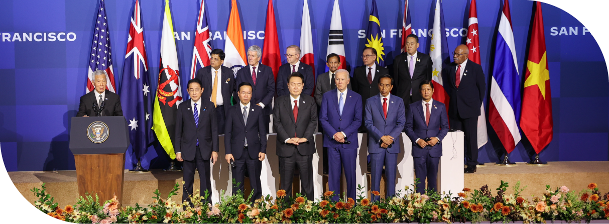 Politicians from 14 countries gathering on stage, with flags placed at the back. Then PM Lee is making a speech.