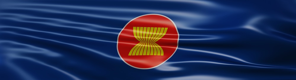 ASEAN flag with red circle and yellow stalks on a rippling blue background.