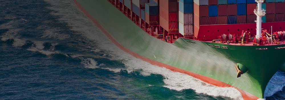 Large cargo ship carrying containers sailing through the ocean.