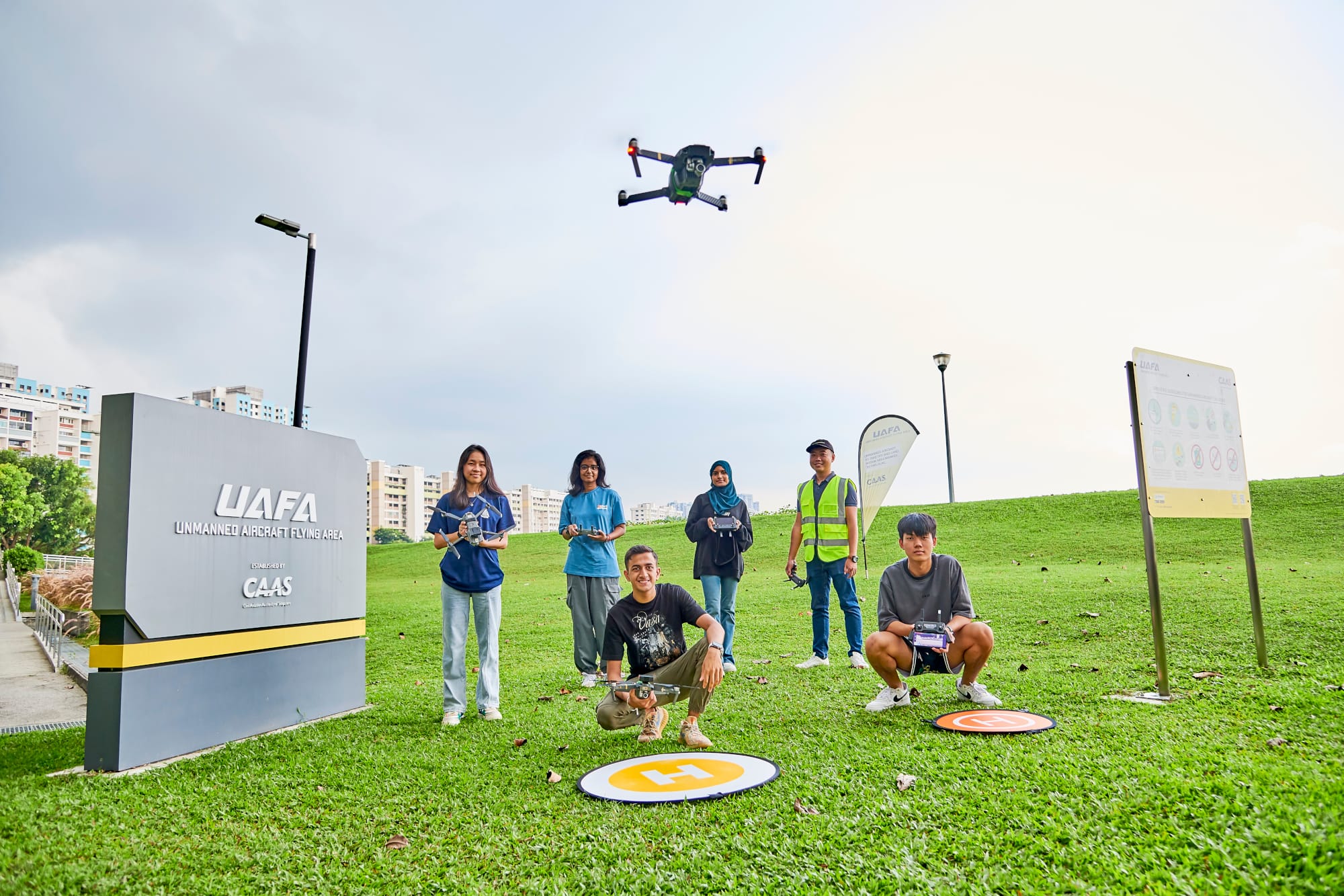 photo of UAFA at Pandan Reservoir, and several unmanned aircraft operators standing in front of it