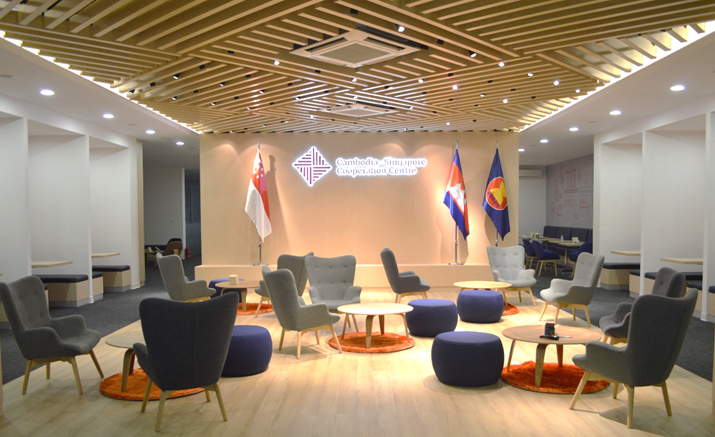 Lounge area: Singapore, Cambodia, and ASEAN flags, plus grey chairs and blue ottomans.