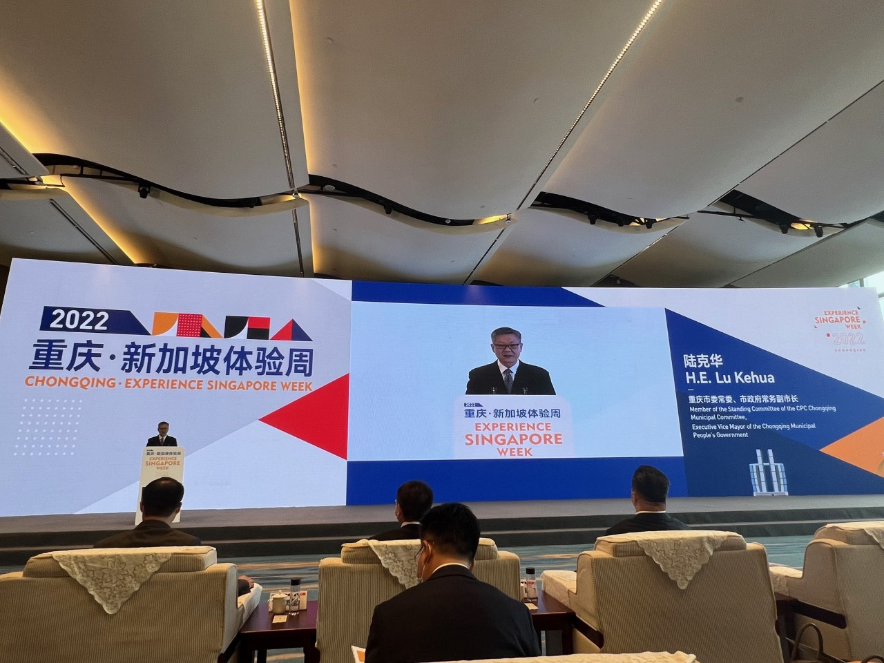 Three people posing indoors; a woman in shawl, two men in light shirts.
