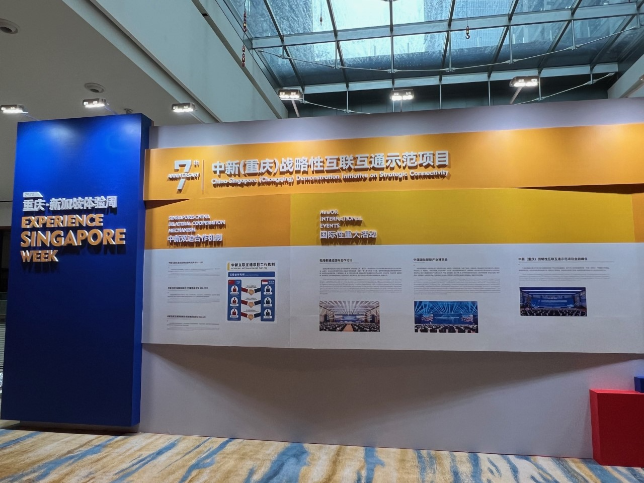 Group of people posing in formal attire in front of screen with Singapore skyline.