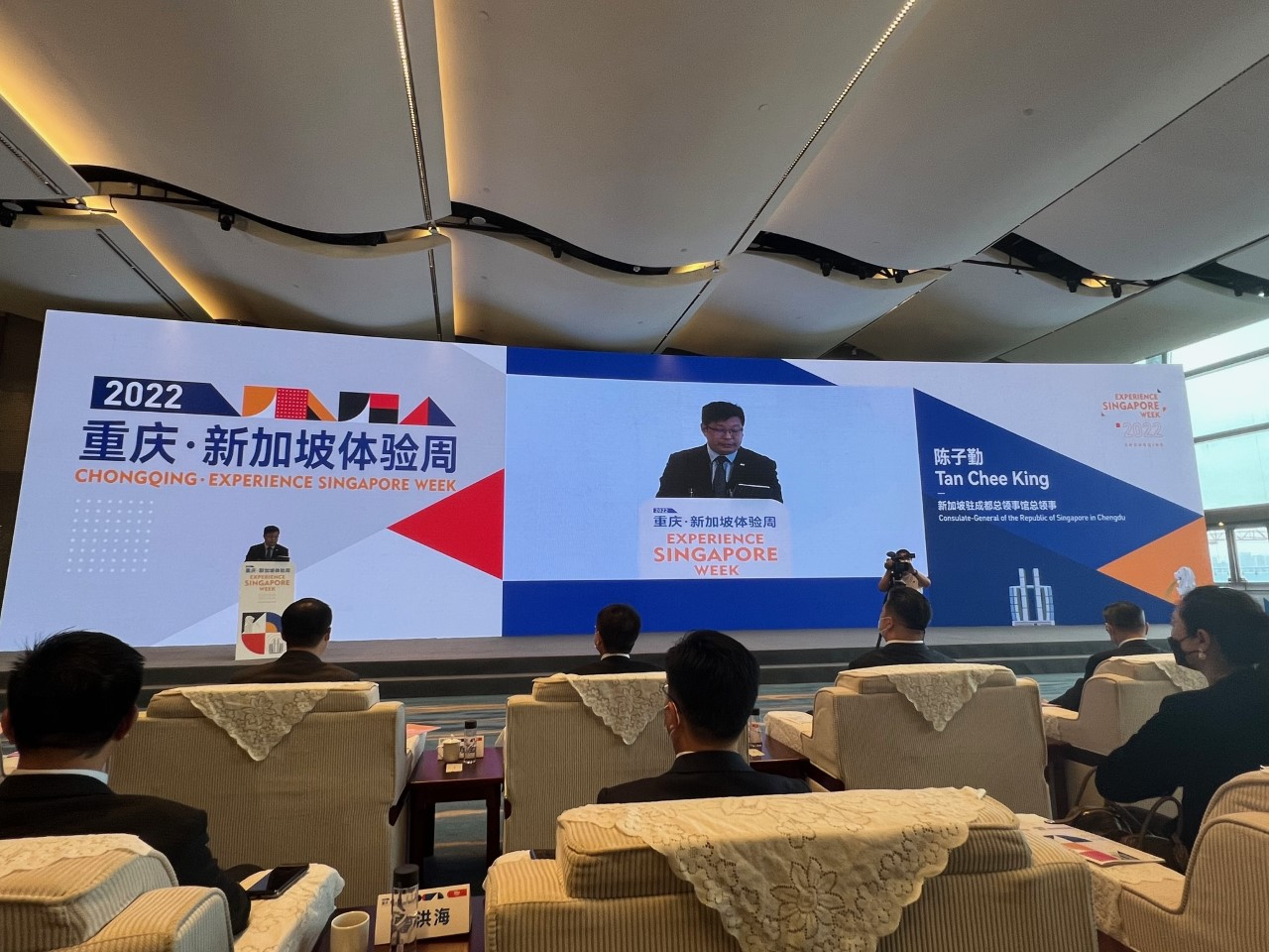 Audience views "Experience Singapore Week" presentation on dual screens. Tan Chee King onscreen.