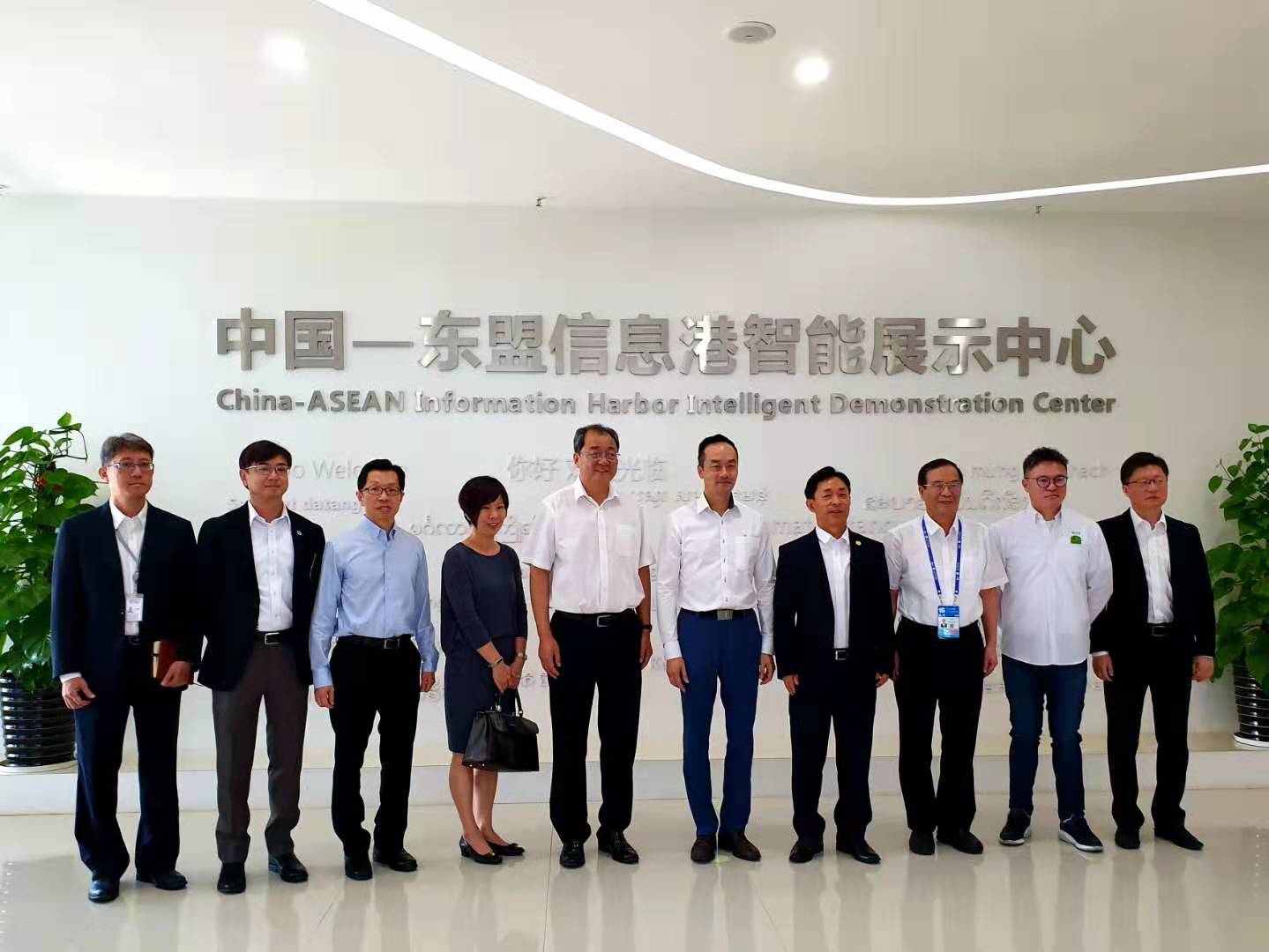 Ten people stand in front of the China-ASEAN Information Harbor Intelligent Demonstration Center sign.