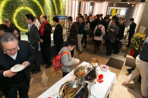 Crowd of people gathering around food stations in an indoor venue.