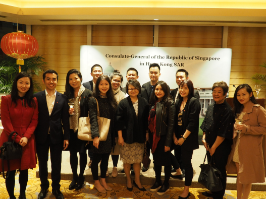 Group of people posing in front of Consulate-General of the Republic of Singapore banner.