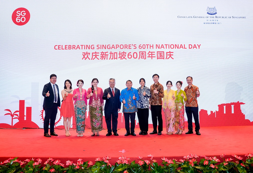 A group on stage celebrating Singapore's 60th National Day with "SG 60" logo.