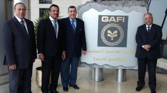 Four men in suits stand beside a GAFI sign written in Arabic and English.