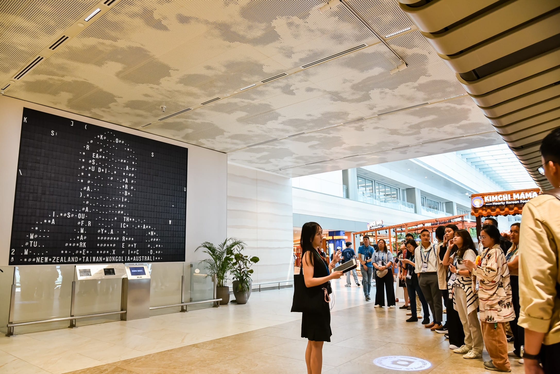 Group of people listening to a guide on their learning journey at Changi Airport.