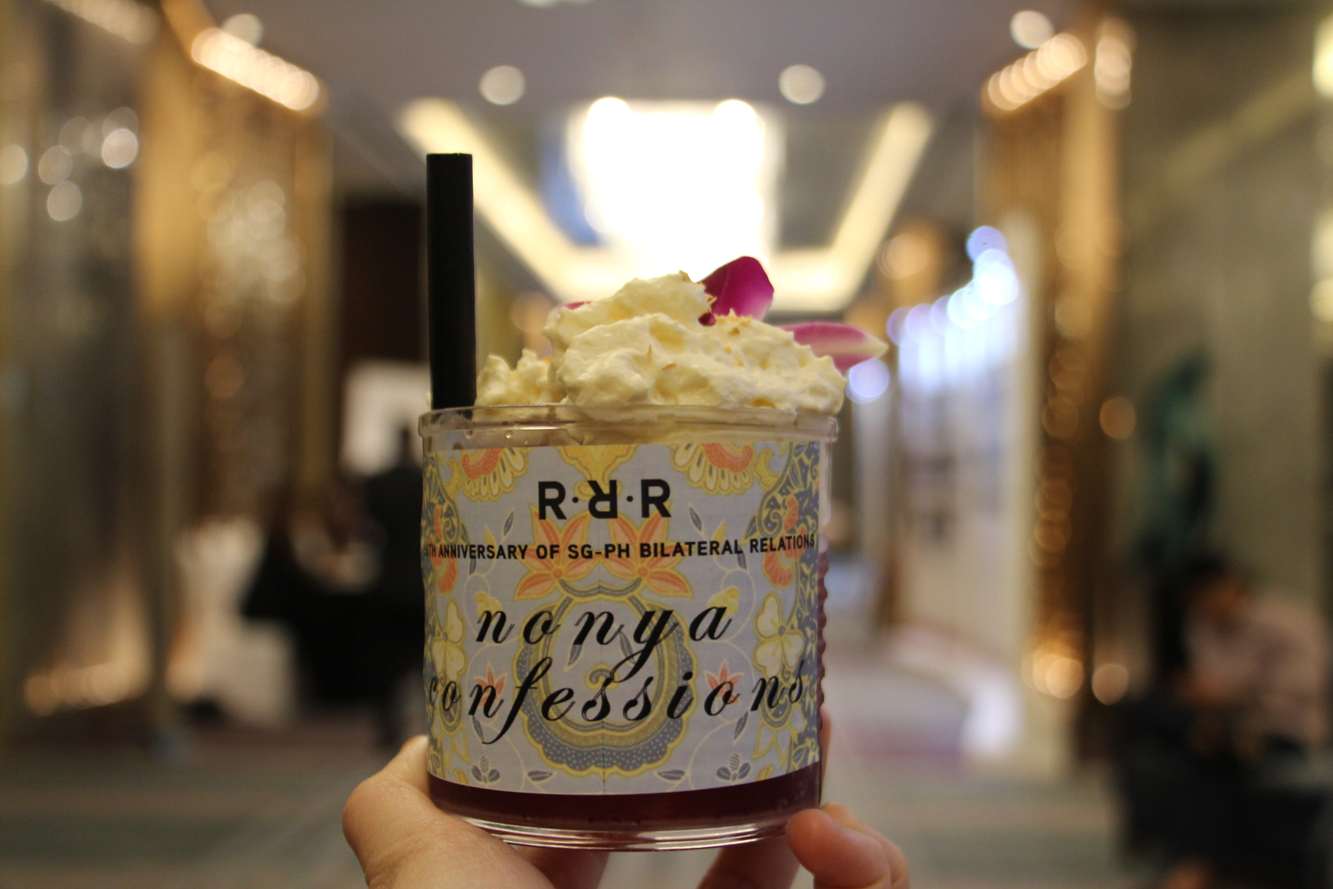 Group of seven people standing indoors against a light-colored wall.