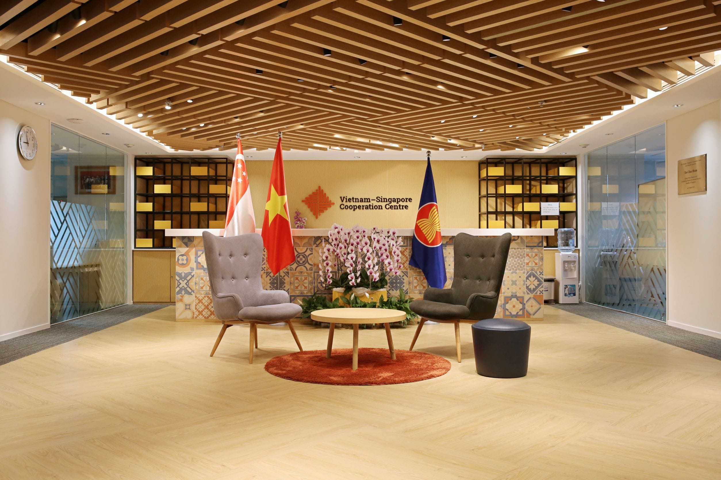 Reception area for Vietnam-Singapore Cooperation Centre with flags, chairs, and wooden ceiling.