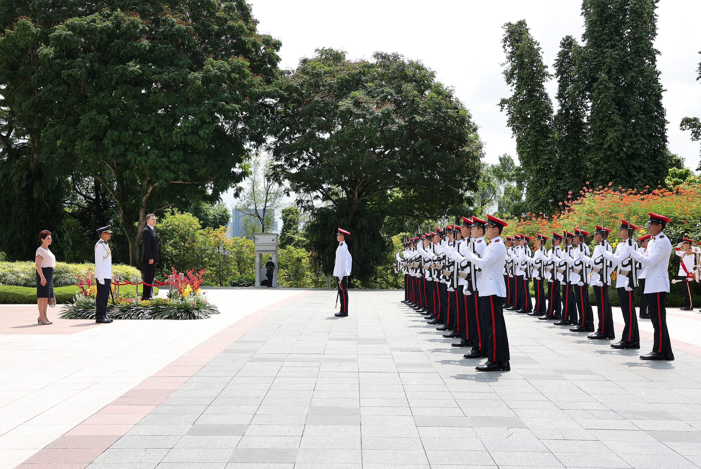 Military honor guard in formation; dignitaries watch ceremony.