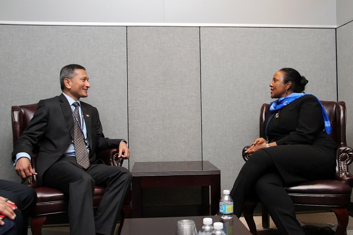 Two people in business attire sitting in armchairs, facing each other in a room.