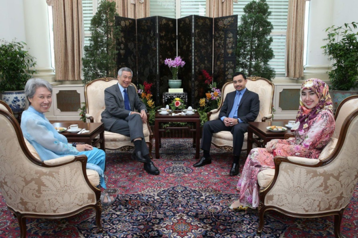 Four people seated in ornate chairs in an elegant room; Lee Hsien Loong is visible.