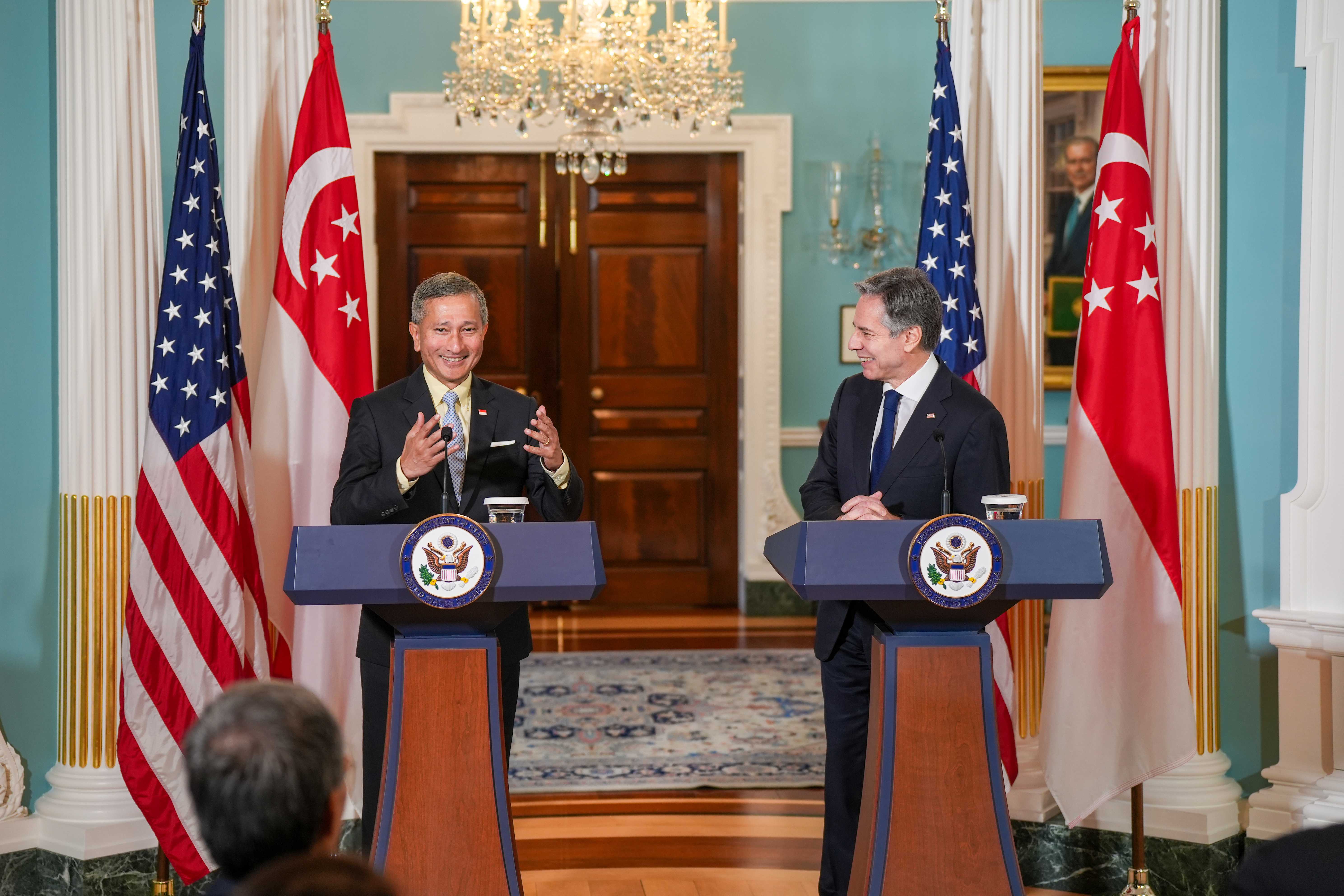 Blinken and Singaporean PM stand at podiums with US and Singapore flags.